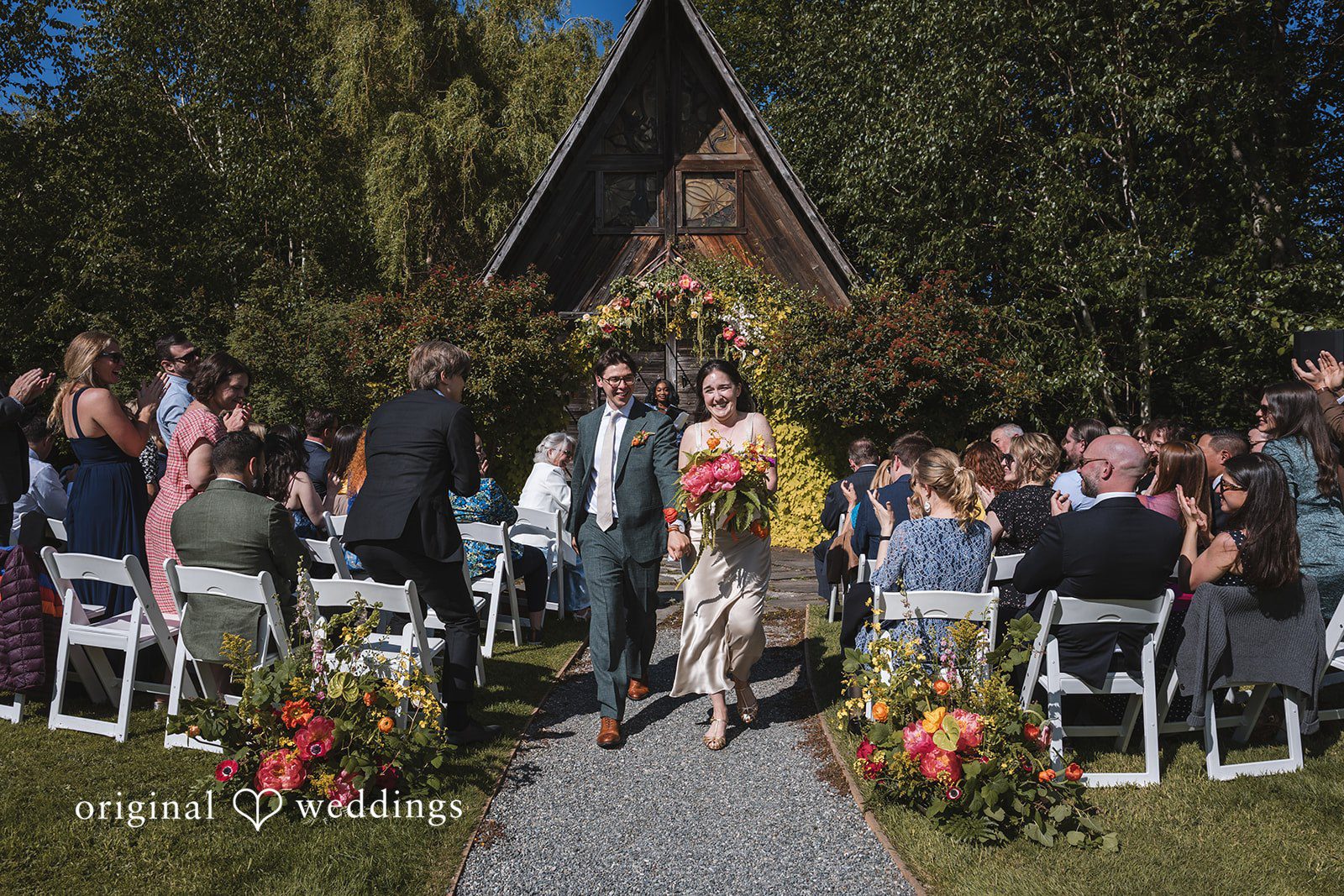 Benjamin + Amber The newly married couple walks down the aisle smiling as guests applaud their joyful celebration