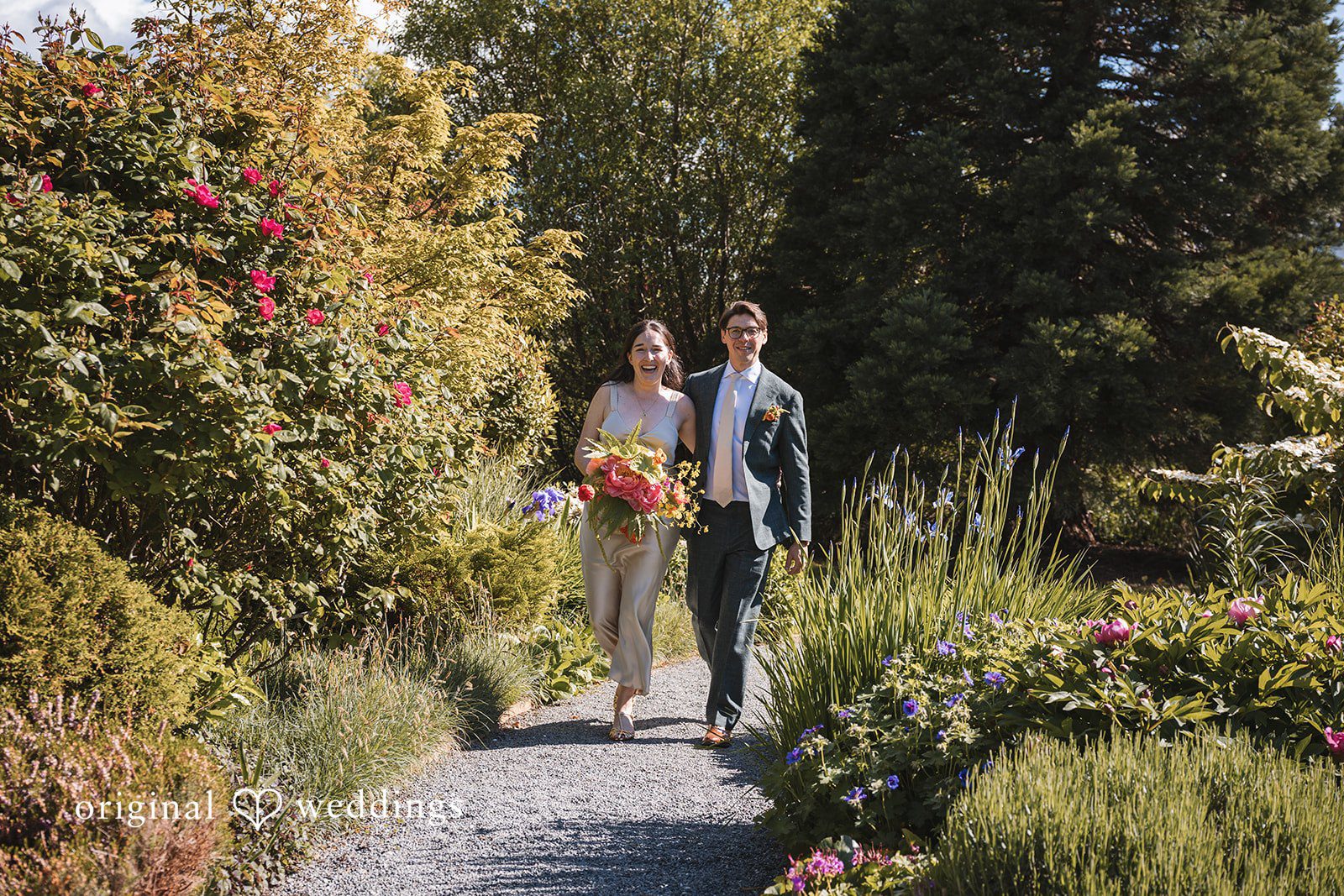 Benjamin + Amber The newlyweds stroll through lush gardens with joyful smiles after their ceremony