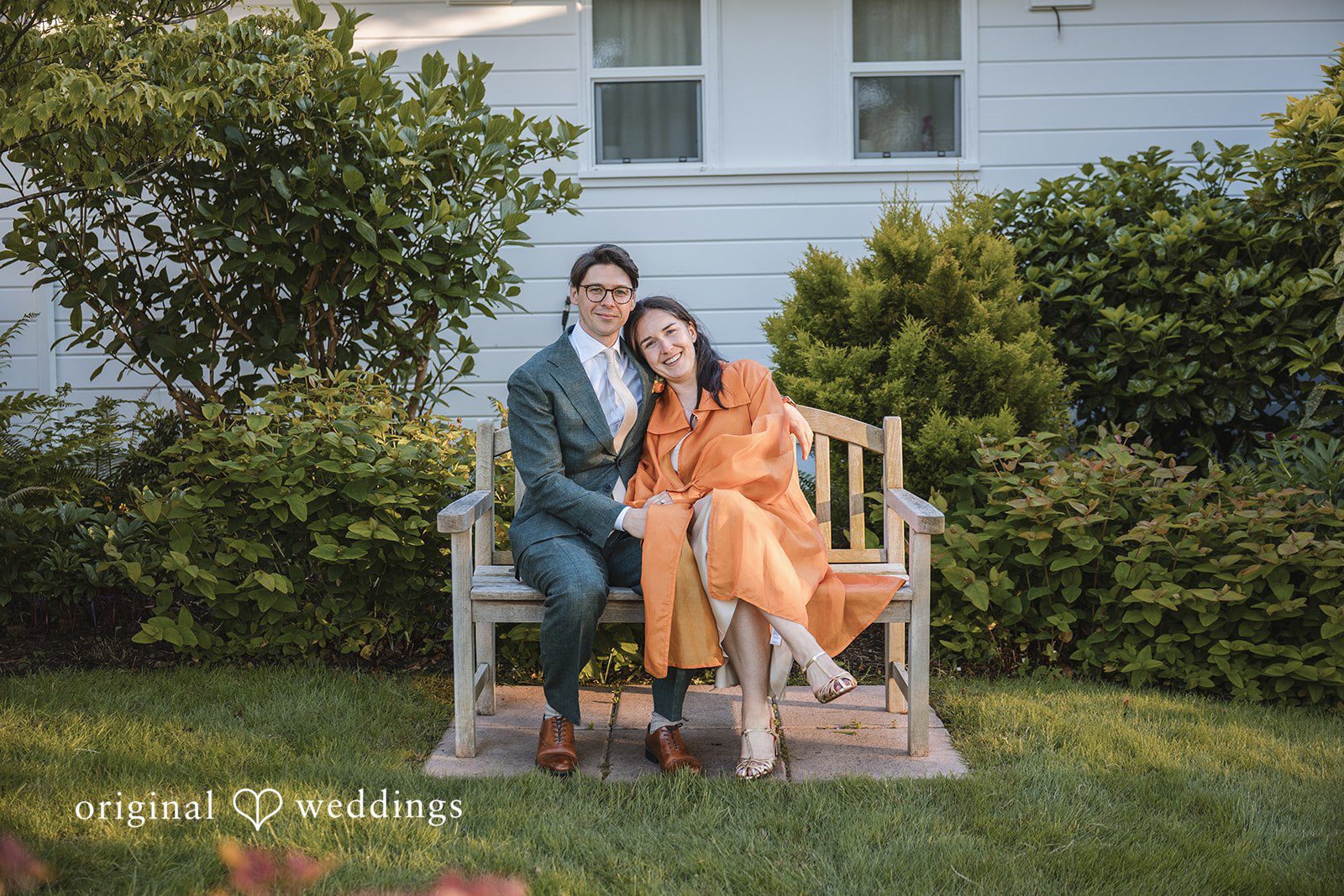 Benjamin + Amber The couple shares a cozy moment on a garden bench, smiling together after their wedding celebration