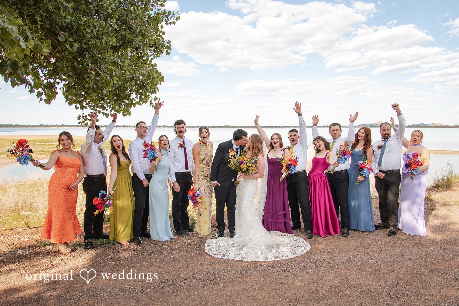 Brekyn + Benjie Our Oklahoma City wedding photographers captured a romantic portrait of the couple with cheers from their bridal party at Quartz Mountain State Park