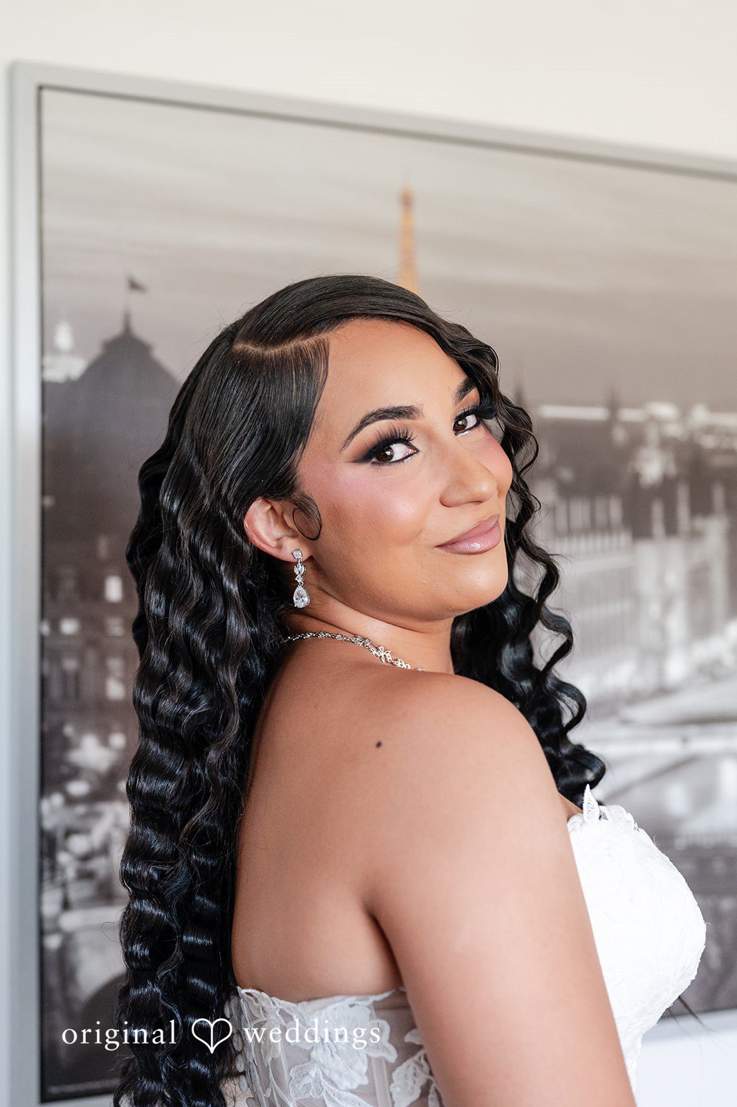 A close-up portrait of a smiling bride with long dark hair at Radiance Event Center.