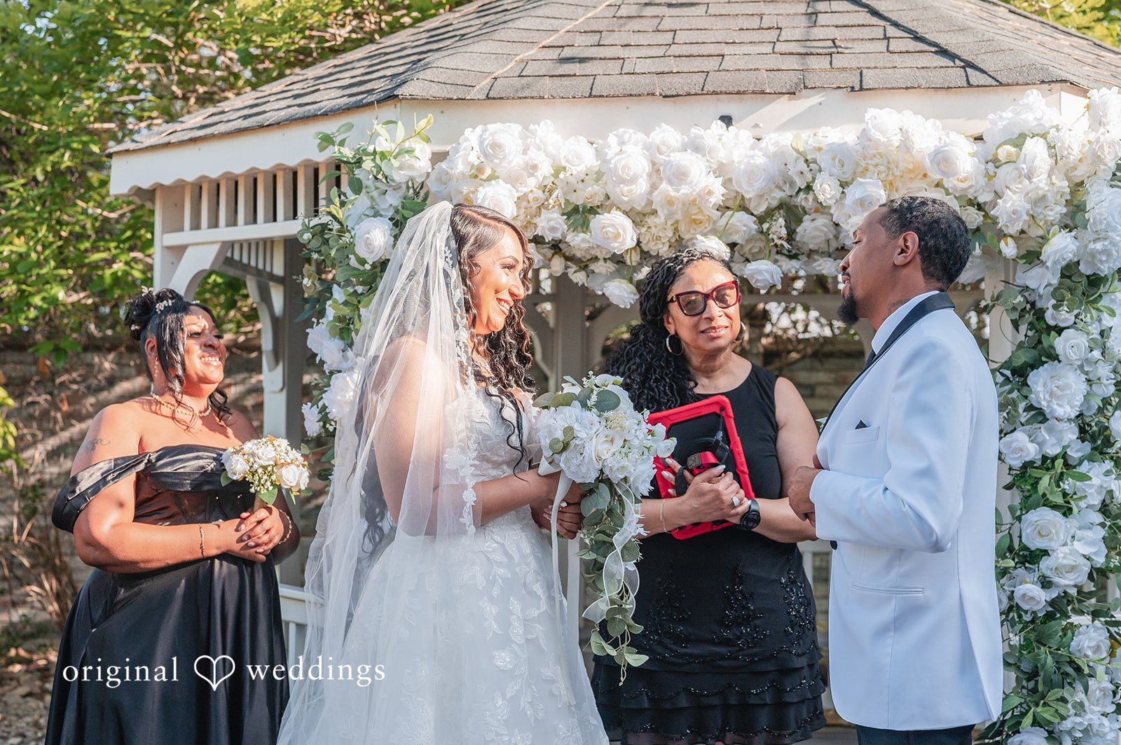 bride and groom holding hands during their wedding ceremony while an officiant speaks.