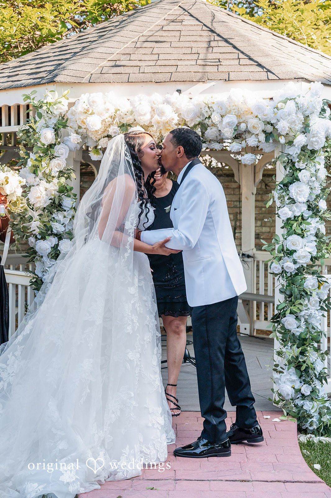 A bride and groom sharing a kiss at the altar during their wedding ceremony.