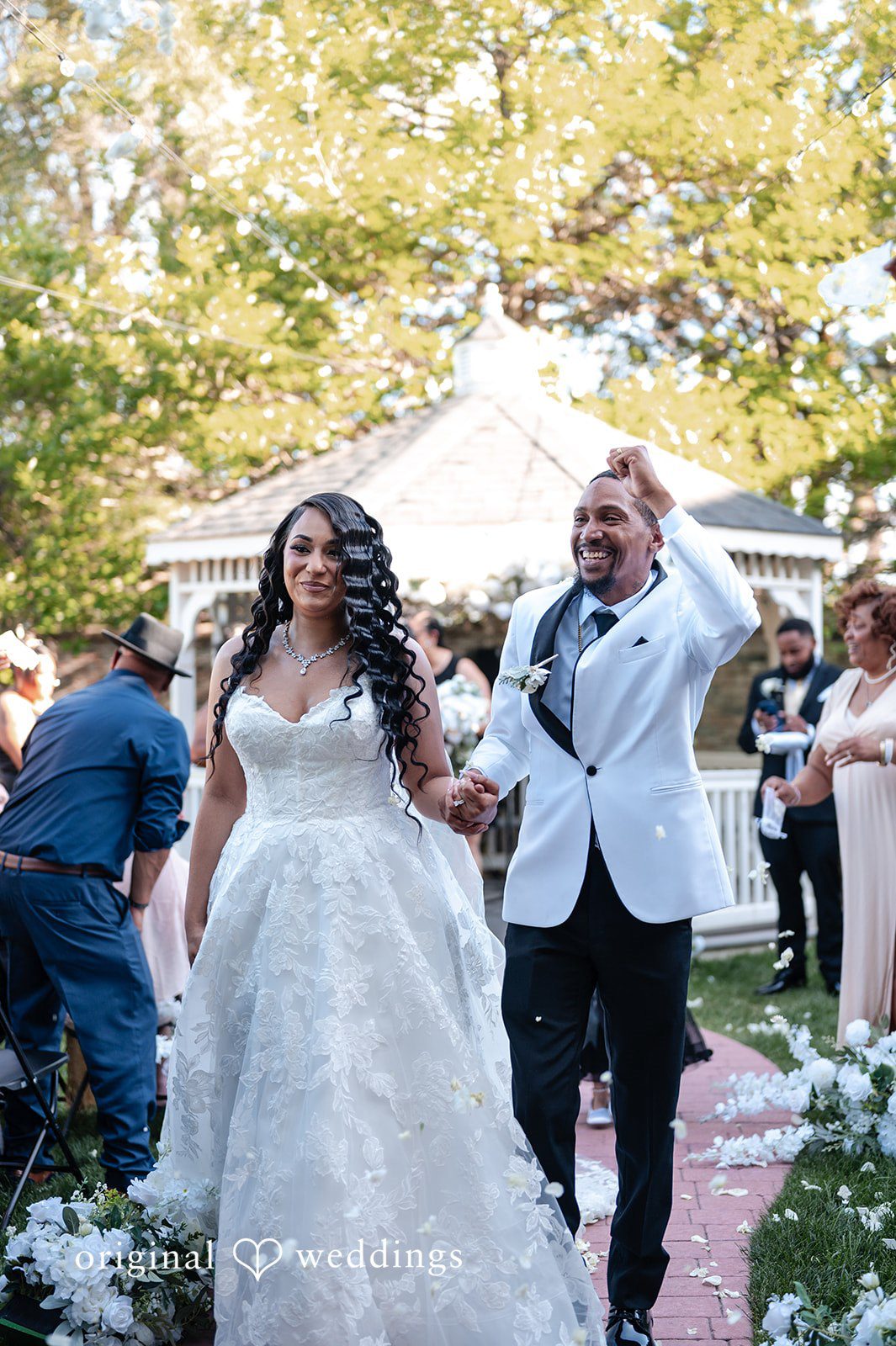 A bride and groom smiling as they walk down the aisle together.