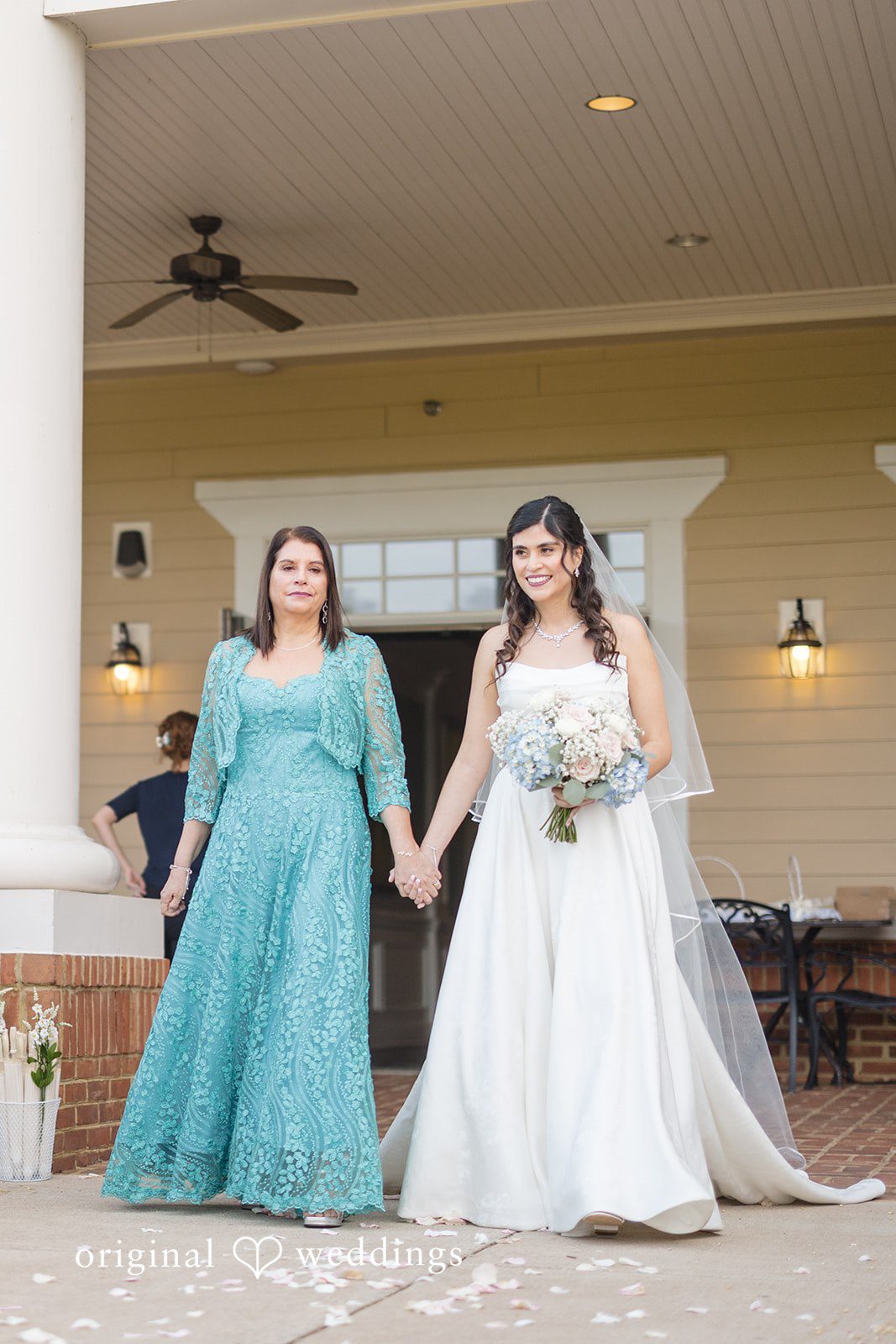 The bride's mother escorts the bride down the aisle