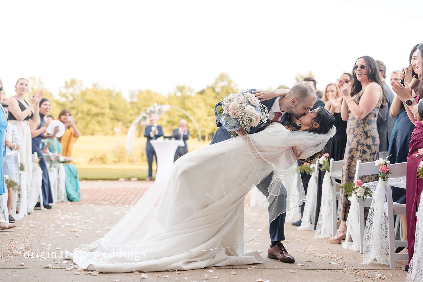The couple shares a passionate kiss on the aisle