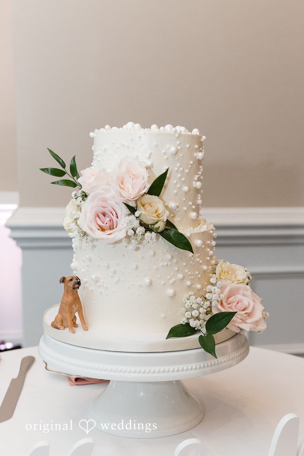 An all-white wedding cake adorned with delicate florals
