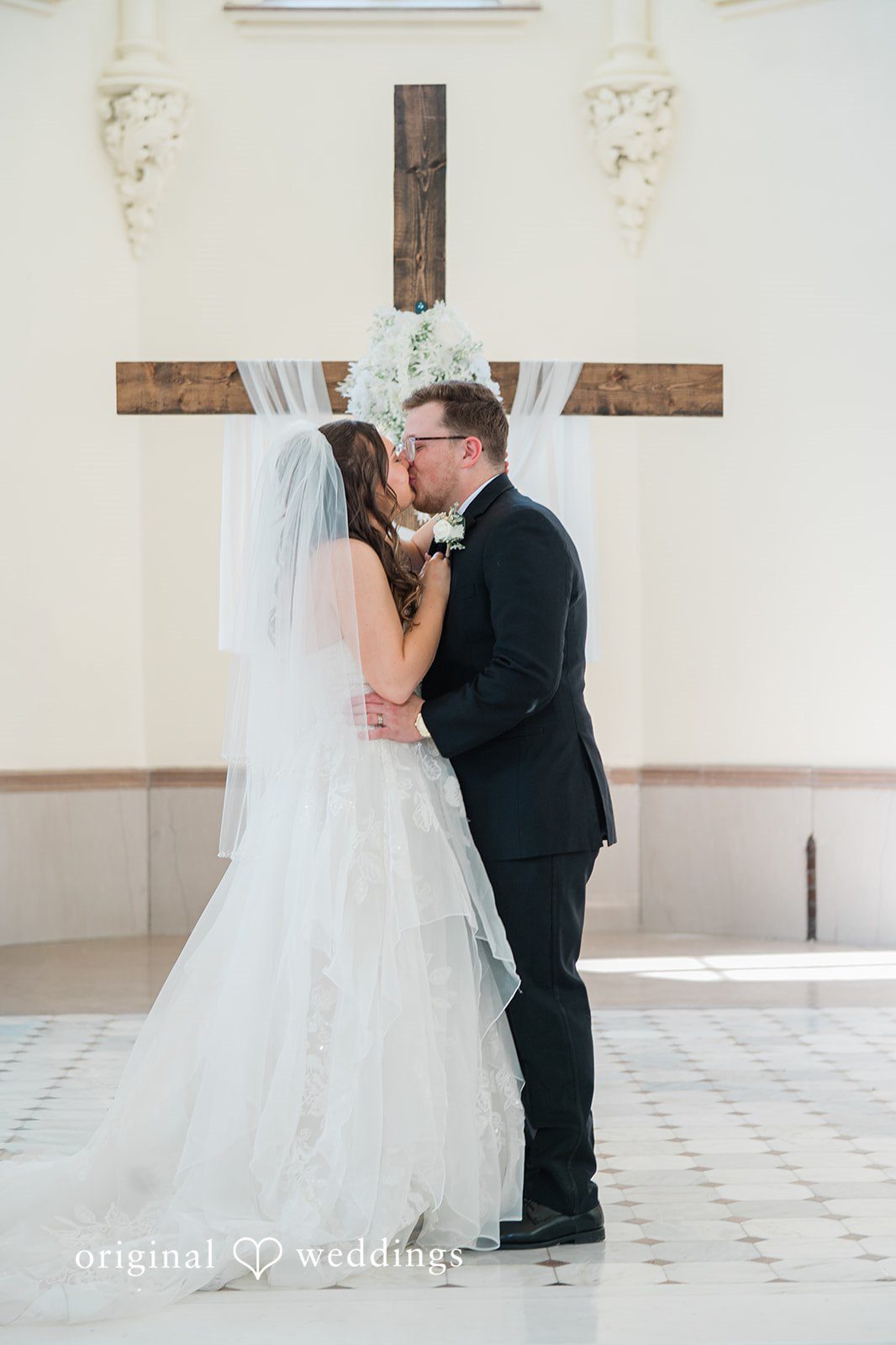 Bride and groom sharing their first kiss after the ceremony