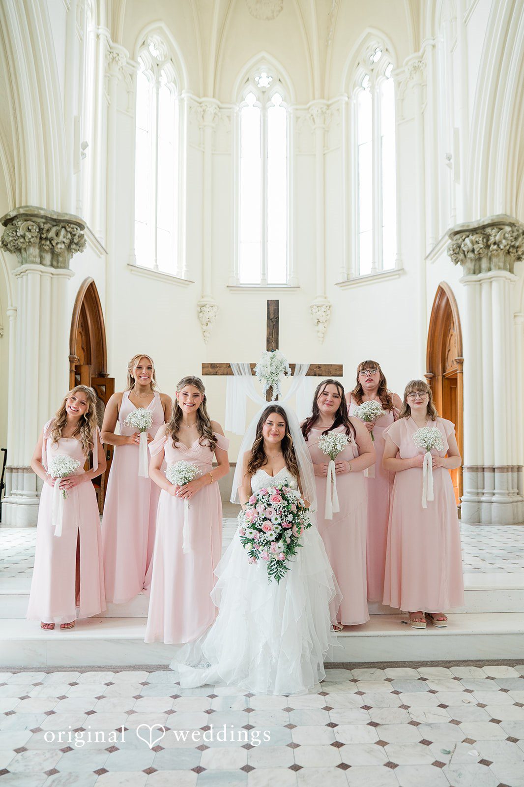 Bride posing with her bridesmaids before the ceremony