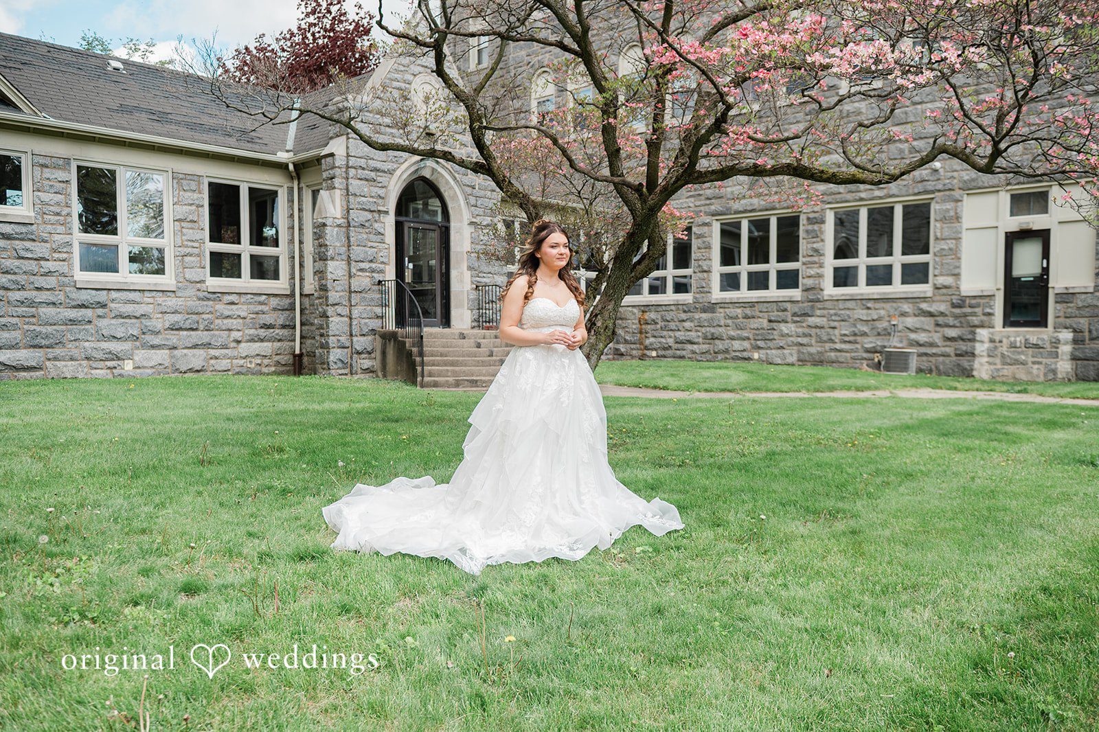 Bride standing outside the venue in a distant outdoor portrait