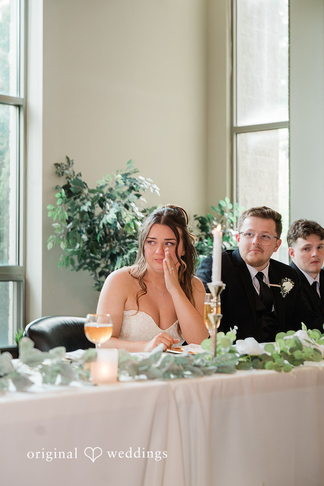 Groom kissing the bride on the forehead during outdoor portraits