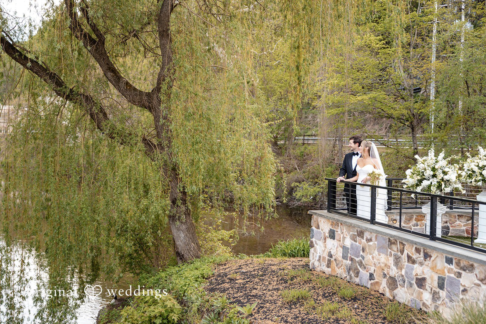 Wide portrait of the bride and groom by the lakeside