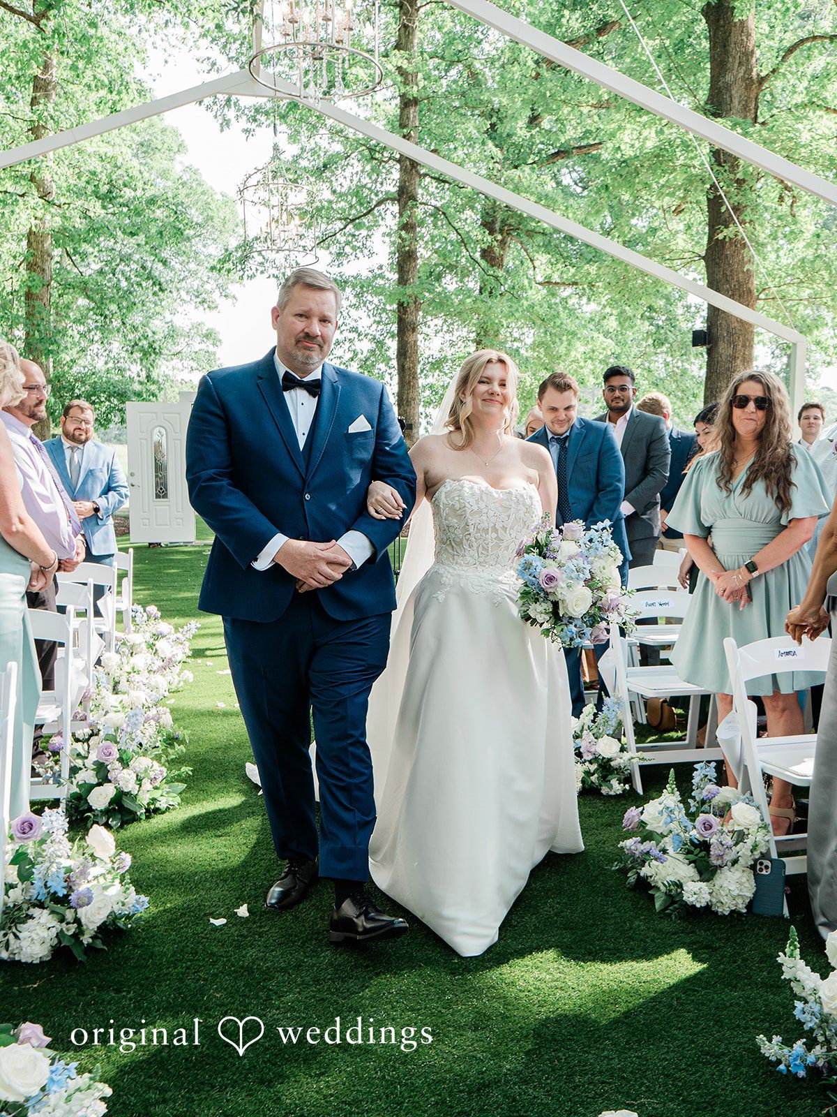The bride's father escorts the bride down the aisle
