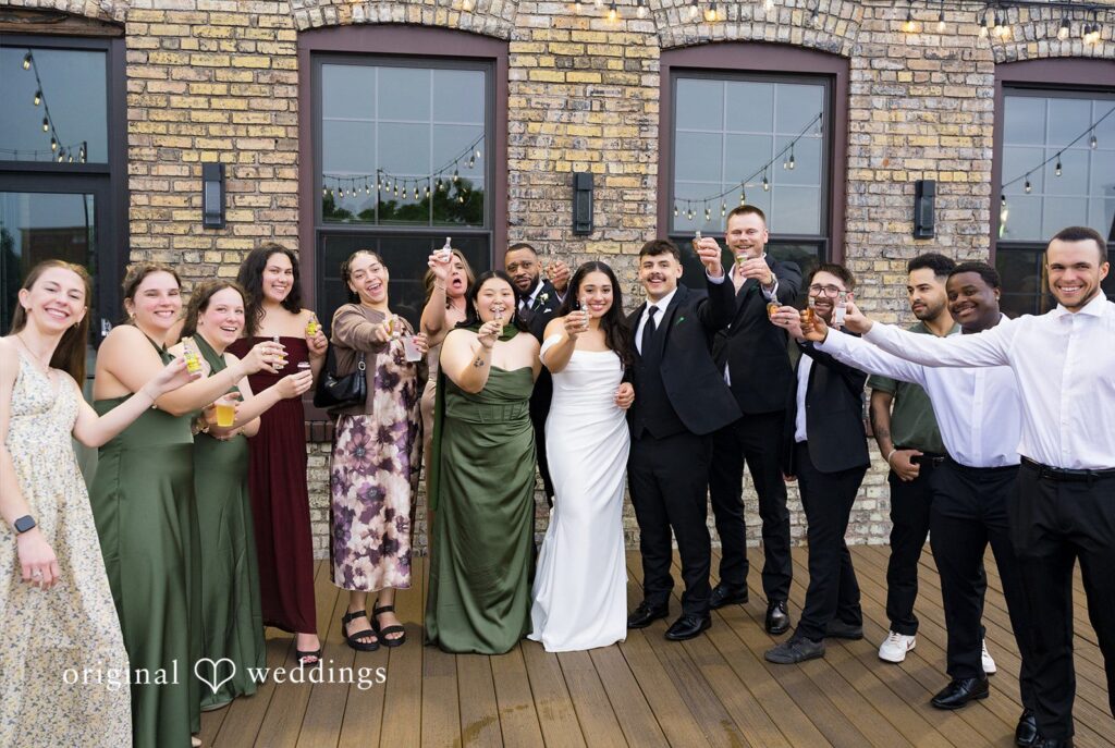 Kiarra + Anthony Minneapolis Wedding Photographers capturing a couple group photo with family and friends at Solar Arts by Original Weddings