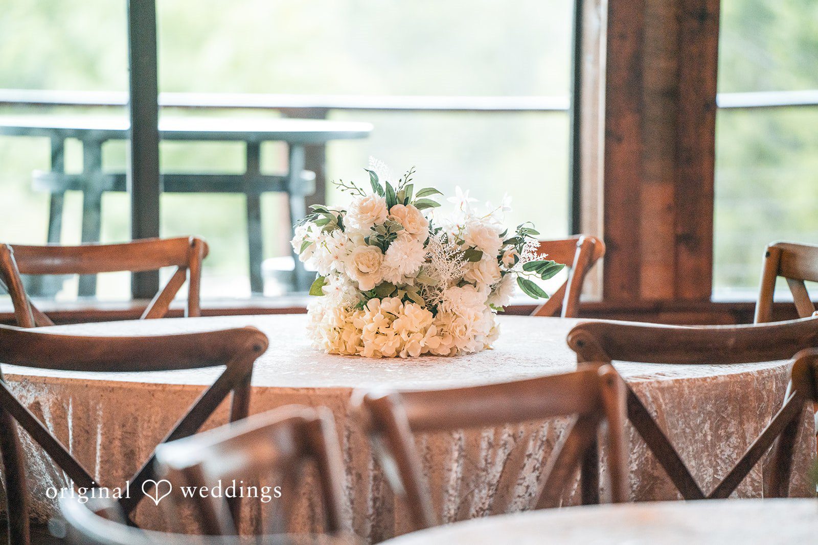 A dining table at a reception decorated with a floral centerpiece at Stone Crest.