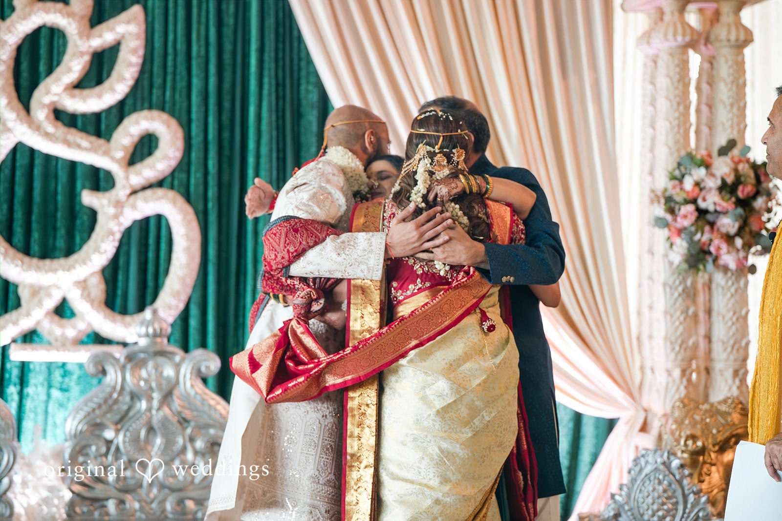 Groom embracing the bride tightly during their traditional wedding ceremony.