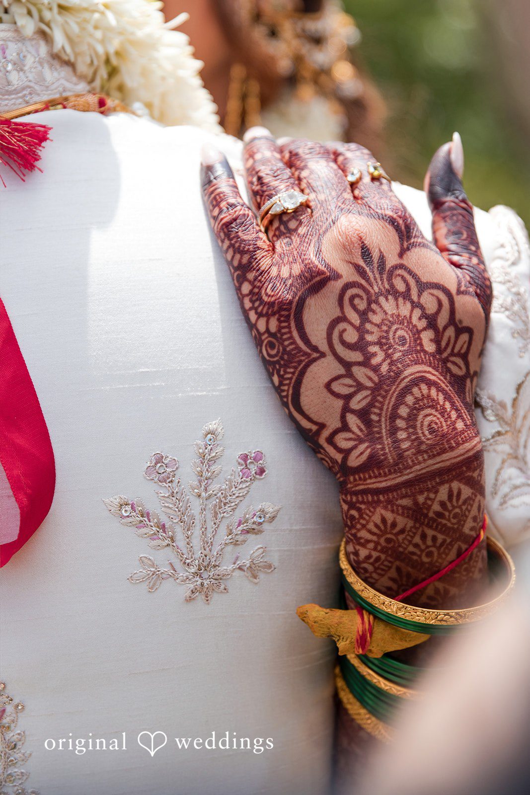 Close-up of a hand decorated with intricate henna patterns.