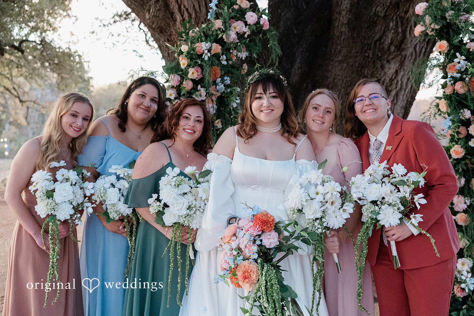 Brittney + Benjamin A bride smiling alongside her bridesmaids holding white bouquets.