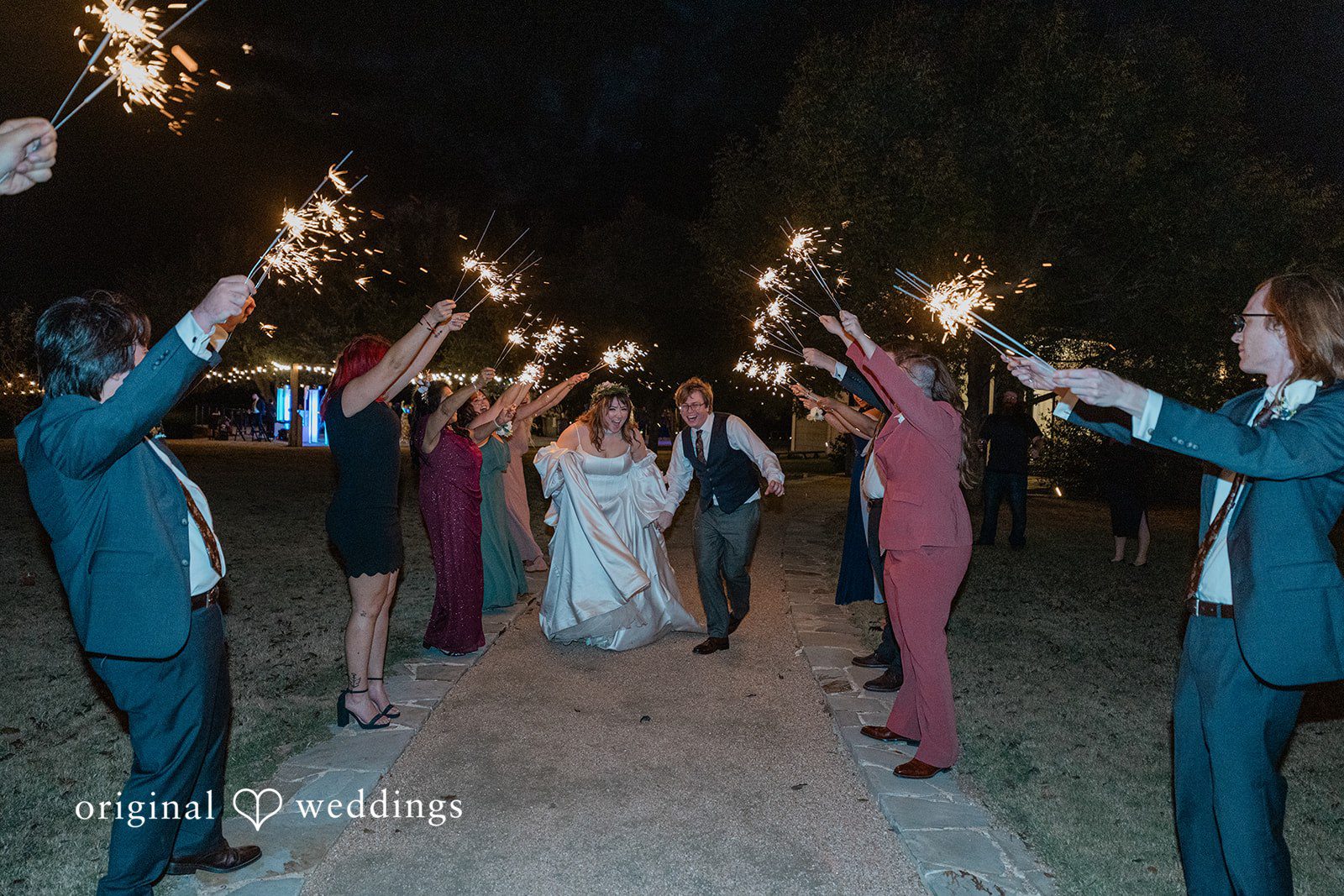 Brittney + Benjamin A bride and groom walking through a wedding sparkler grand exit line.
