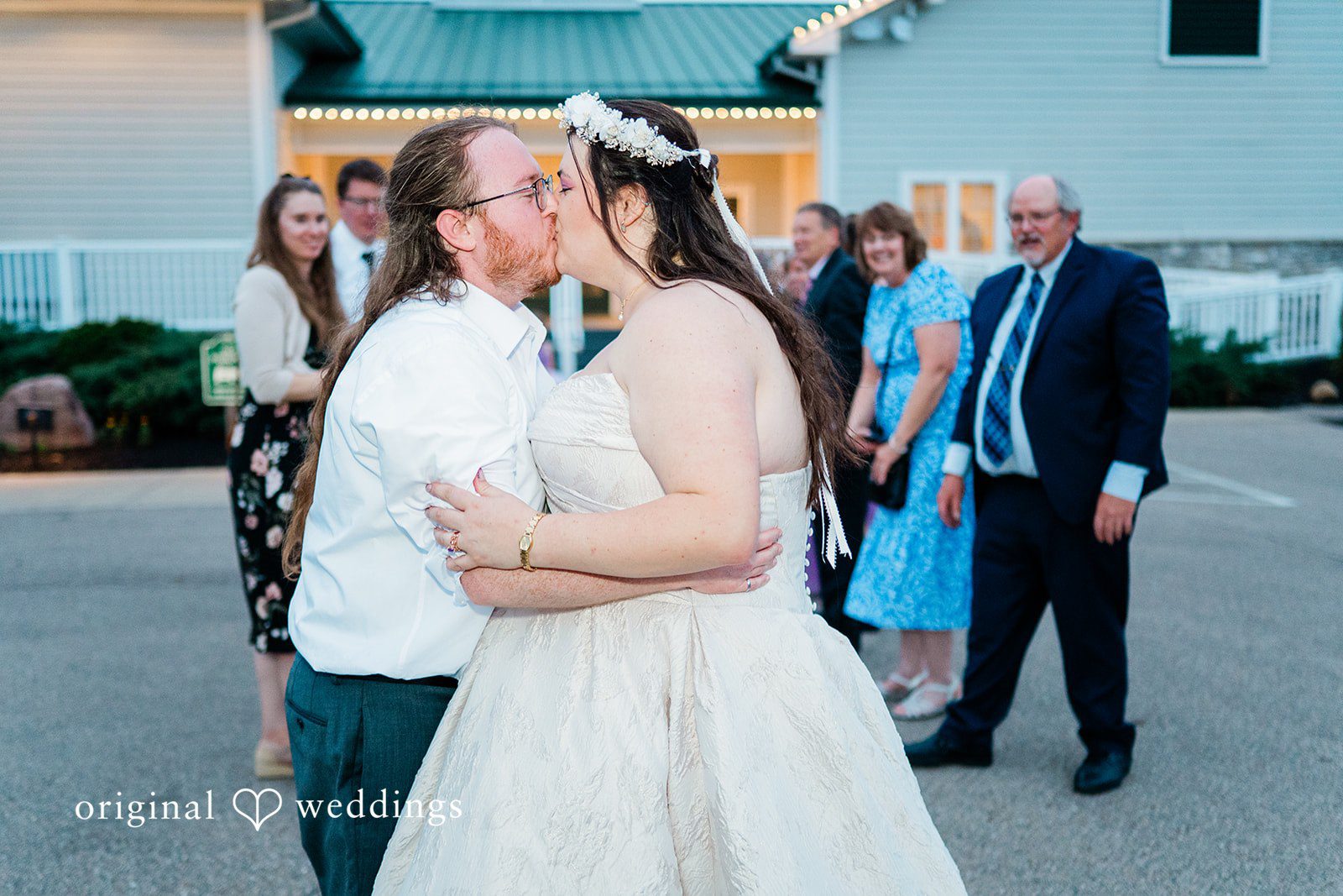 Couple sharing a kiss while guests cheering around