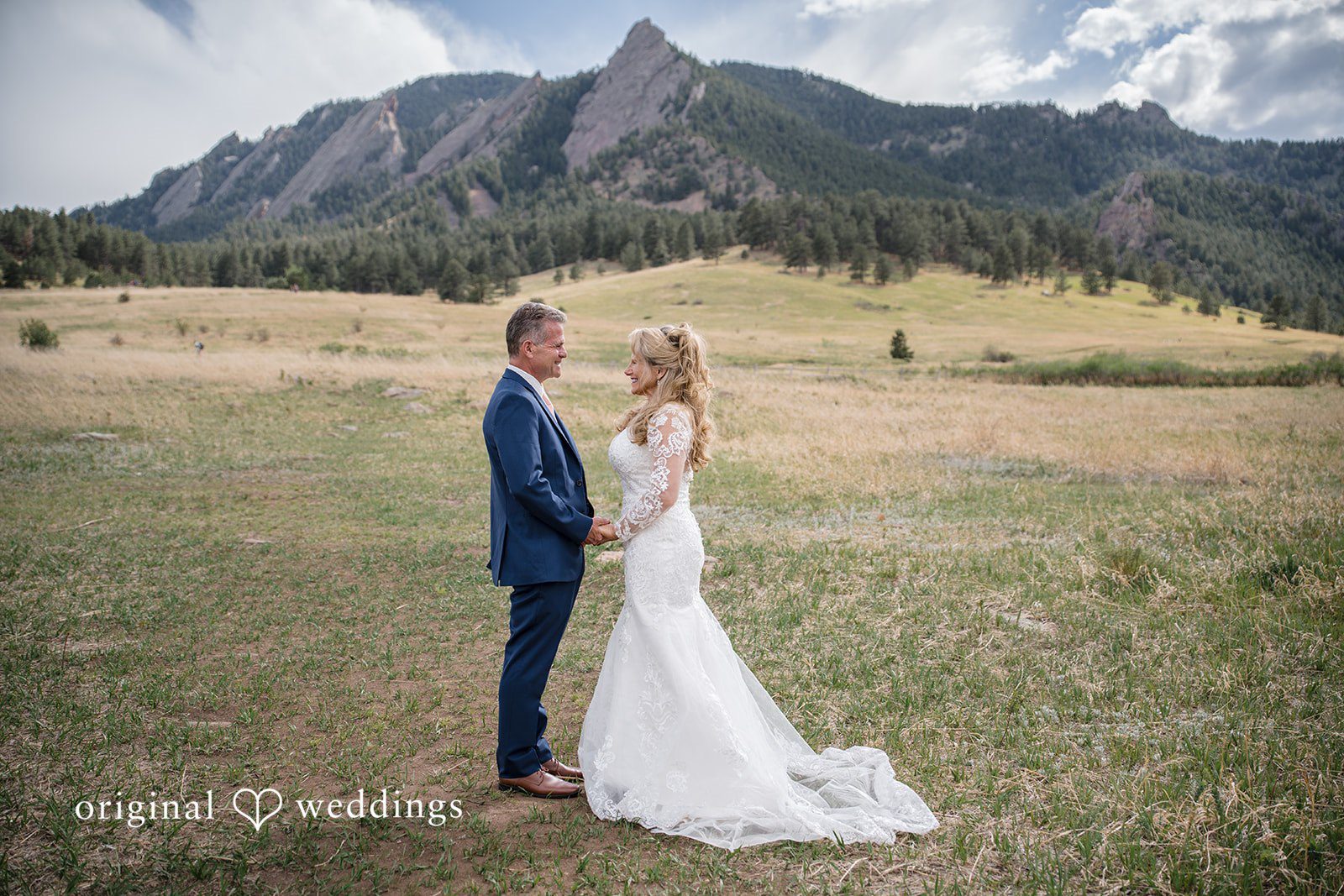 Jacquelyn + Millard Bride and groom sharing a quiet moment with the Flatirons backdrop at Sunrise Amphitheater.