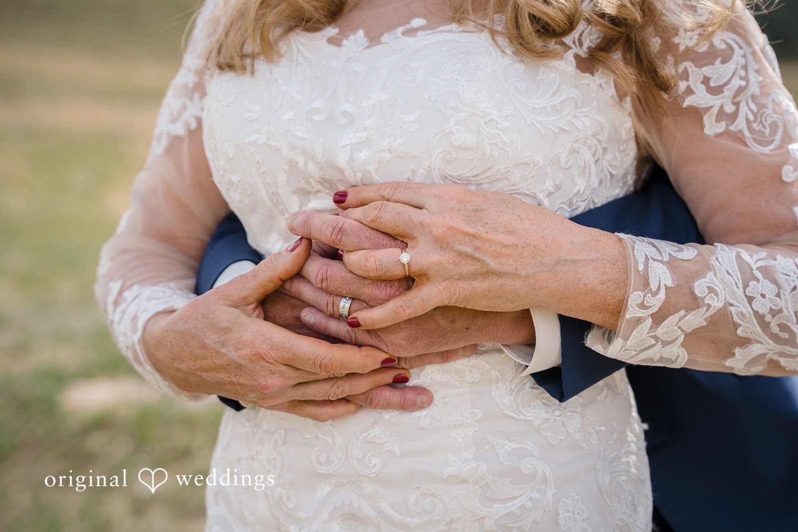 Jacquelyn + Millard Close-up of the bride’s ring and couple’s hands embracing during portraits.