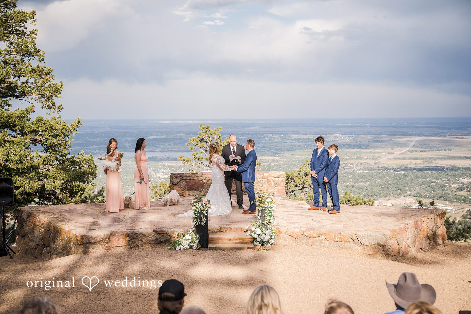 Jacquelyn + Millard Wide ceremony view of the couple exchanging vows at Sunrise Amphitheater captured by Denver wedding photographers from Original Weddings.