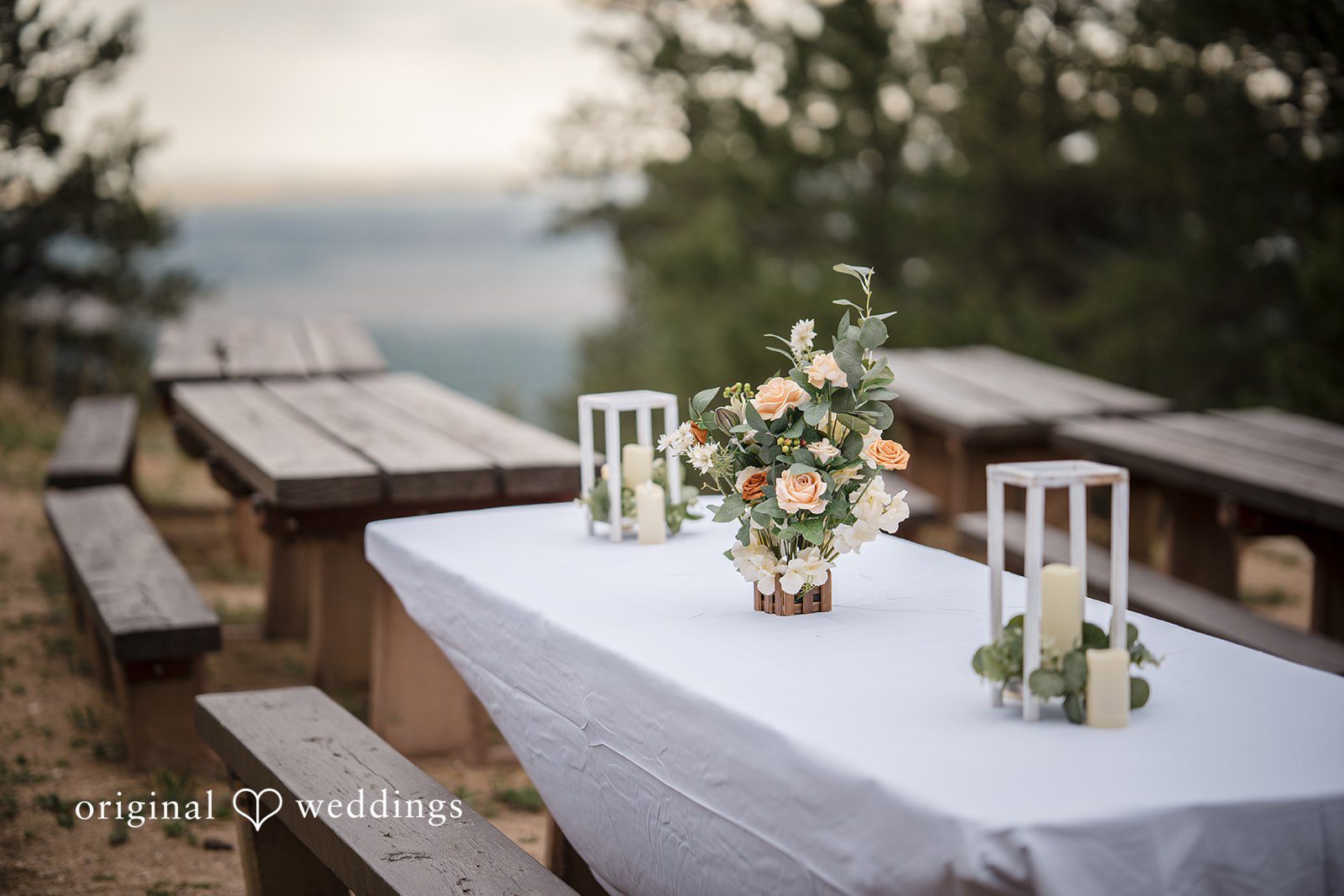 Jacquelyn + Millard Ceremony table with floral décor and candles set for the wedding at Sunrise Amphitheater.