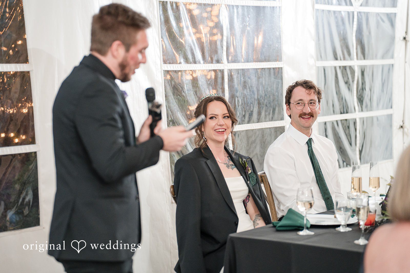 Hannah + Kyle Couple reacting happily to the speech at wedding reception