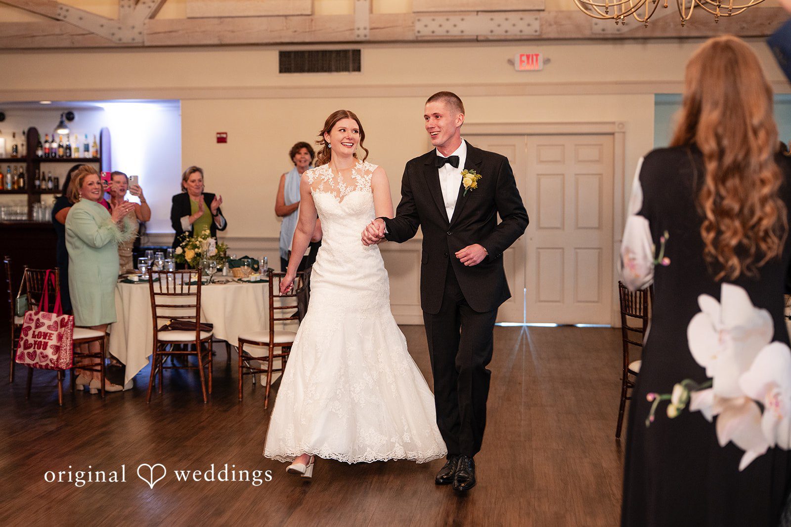 Alanna + Stan Newlyweds make their grand entrance into wedding reception smiling.