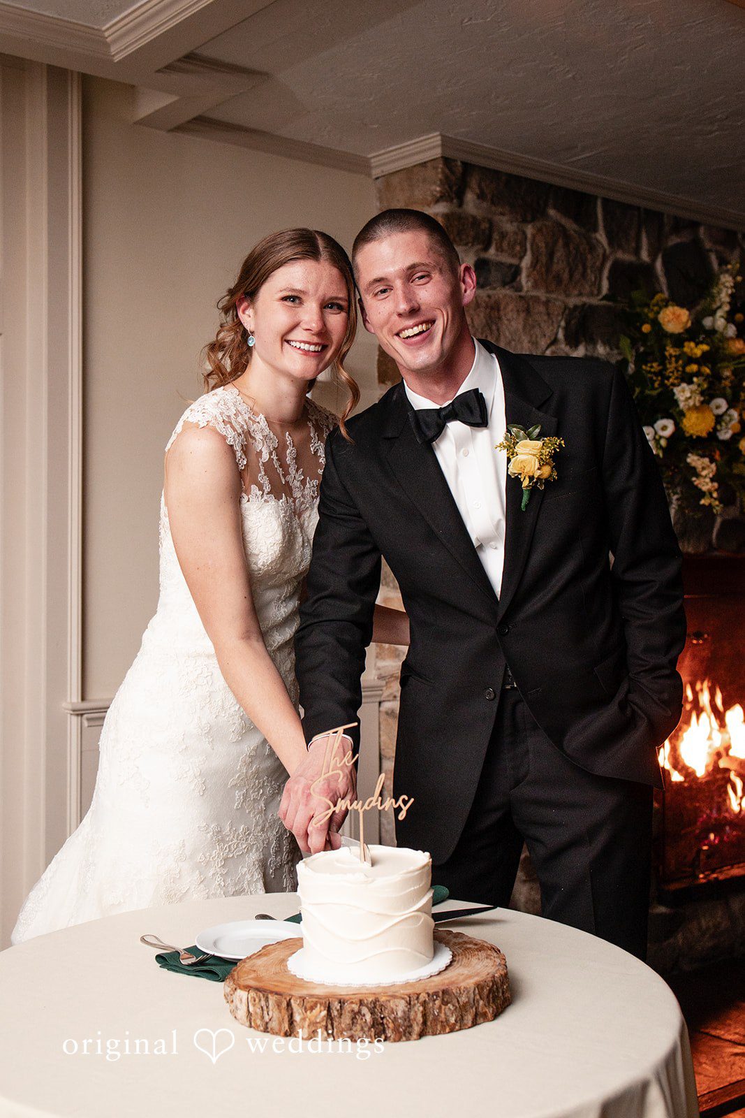 Alanna + Stan Bride and groom smile together while cutting wedding cake .