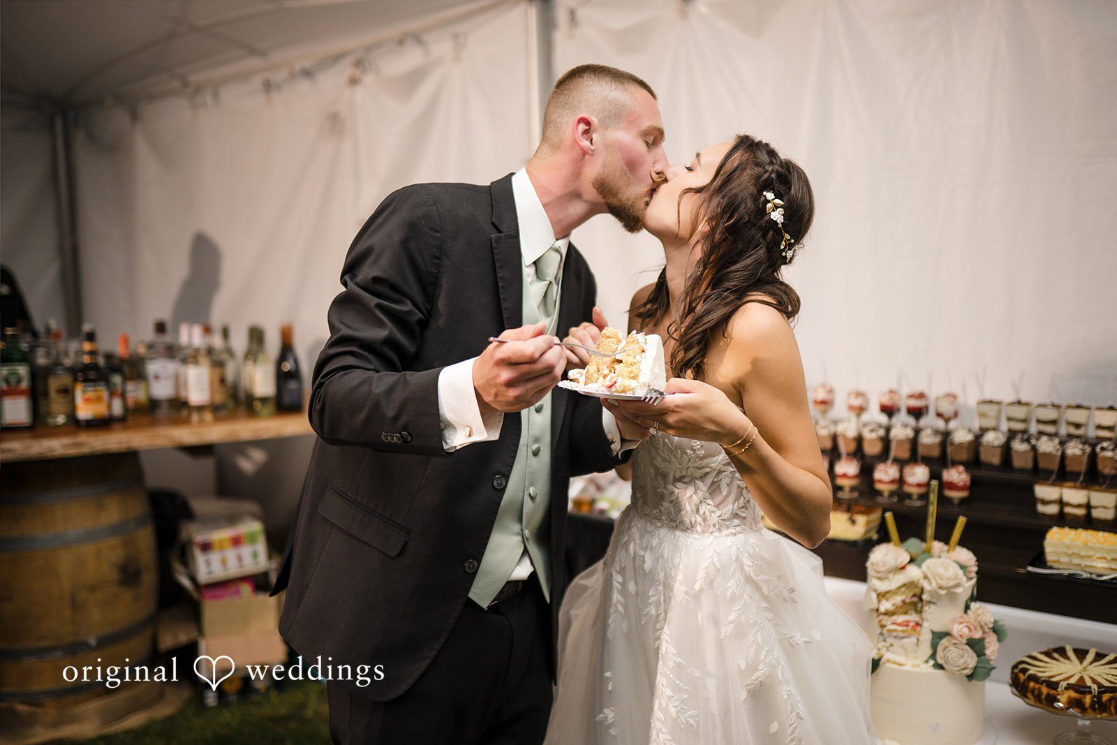 Nicole + Dalton Couple sharing a sweet kiss while eating cake
