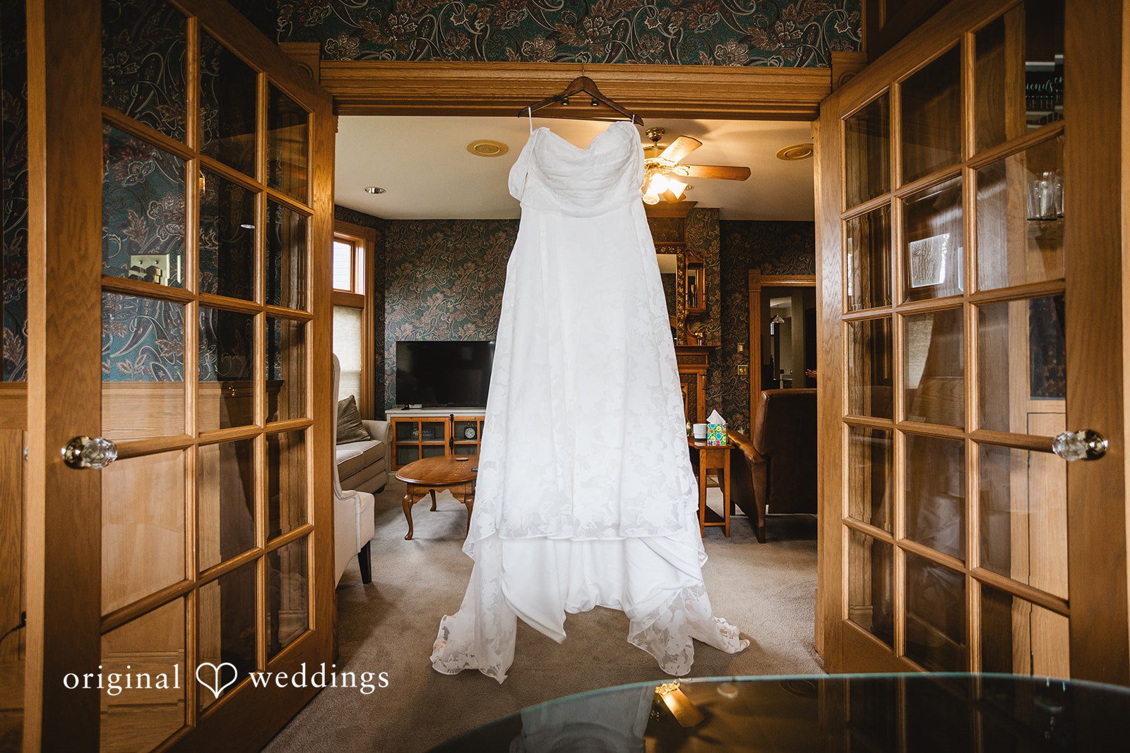 A white wedding dress hanging in an open wooden doorway at The Barrel House.