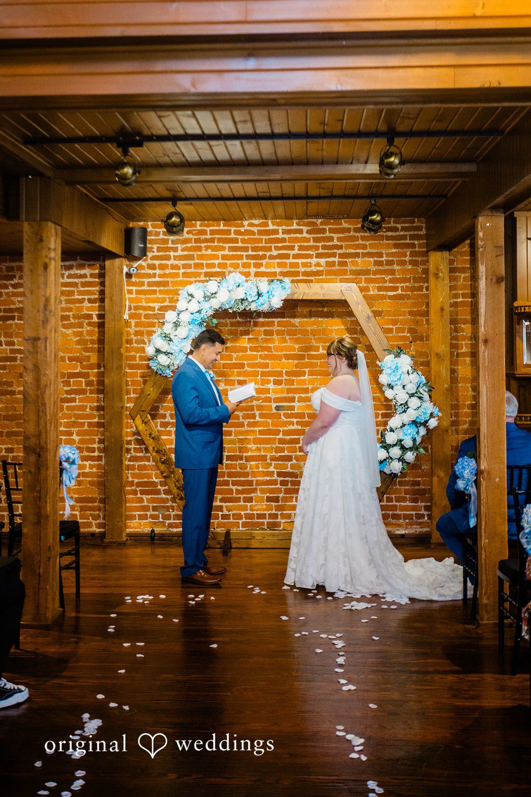 A bride and groom standing at the altar in front of a wooden arch.