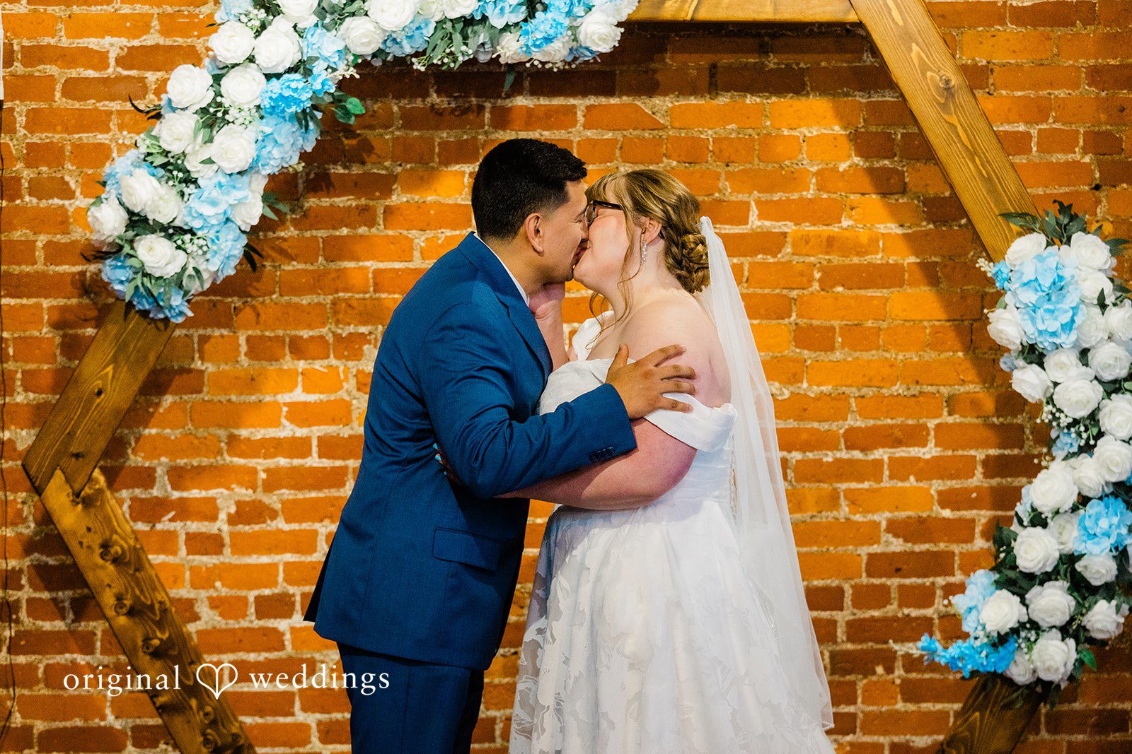 A bride and groom sharing a kiss at the altar during their wedding ceremony.