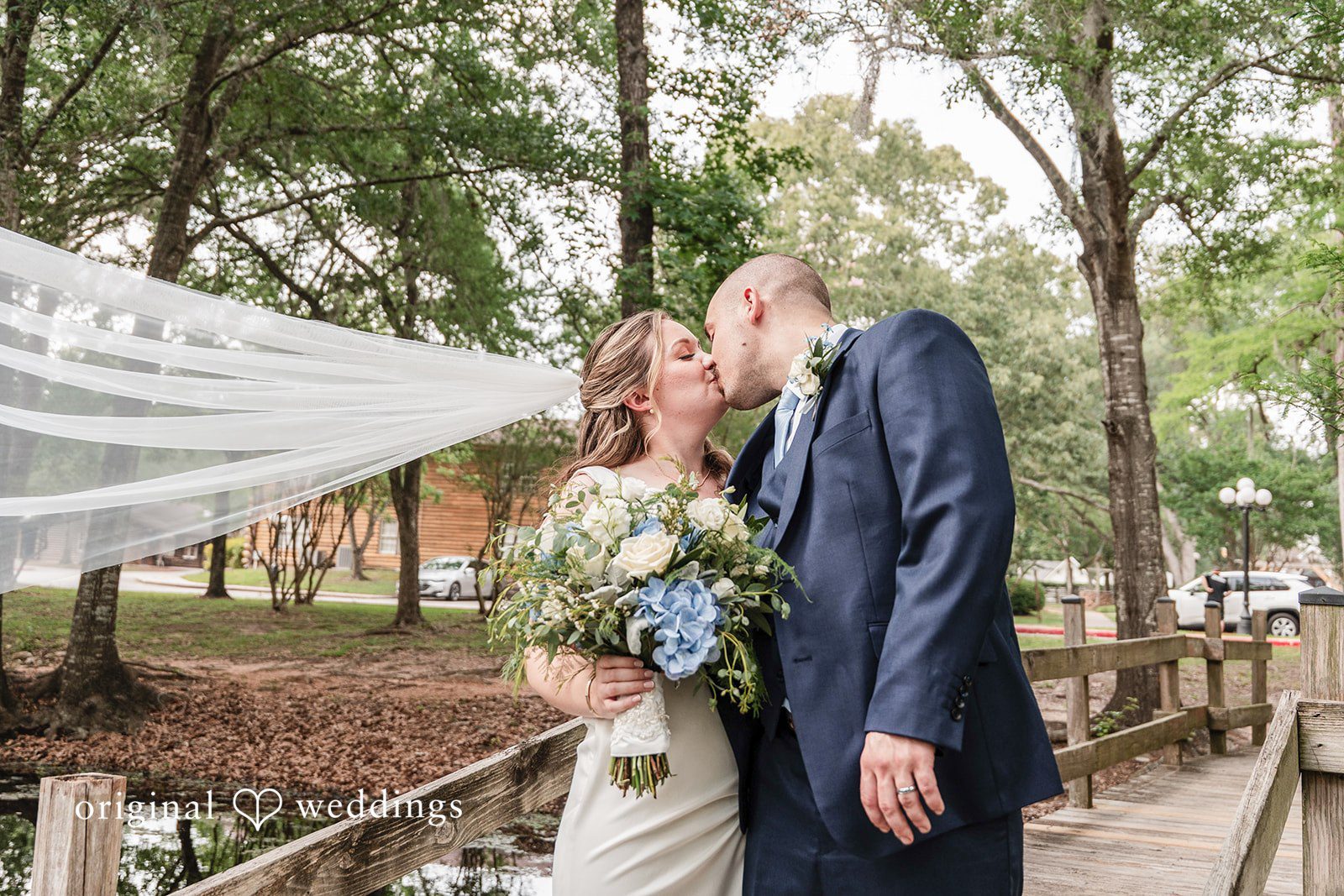 Mary Rose + Nate Bride and groom sharing a kiss in a forest setting