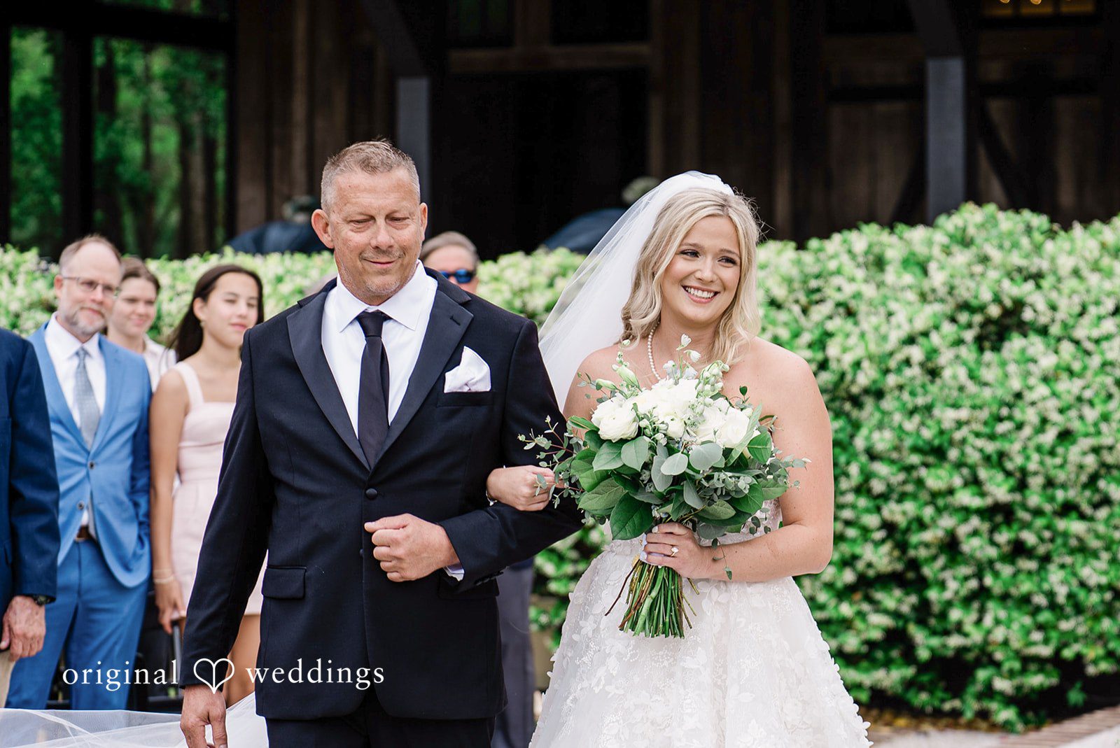 Madeline + John Bride walking with her father toward the ceremony area