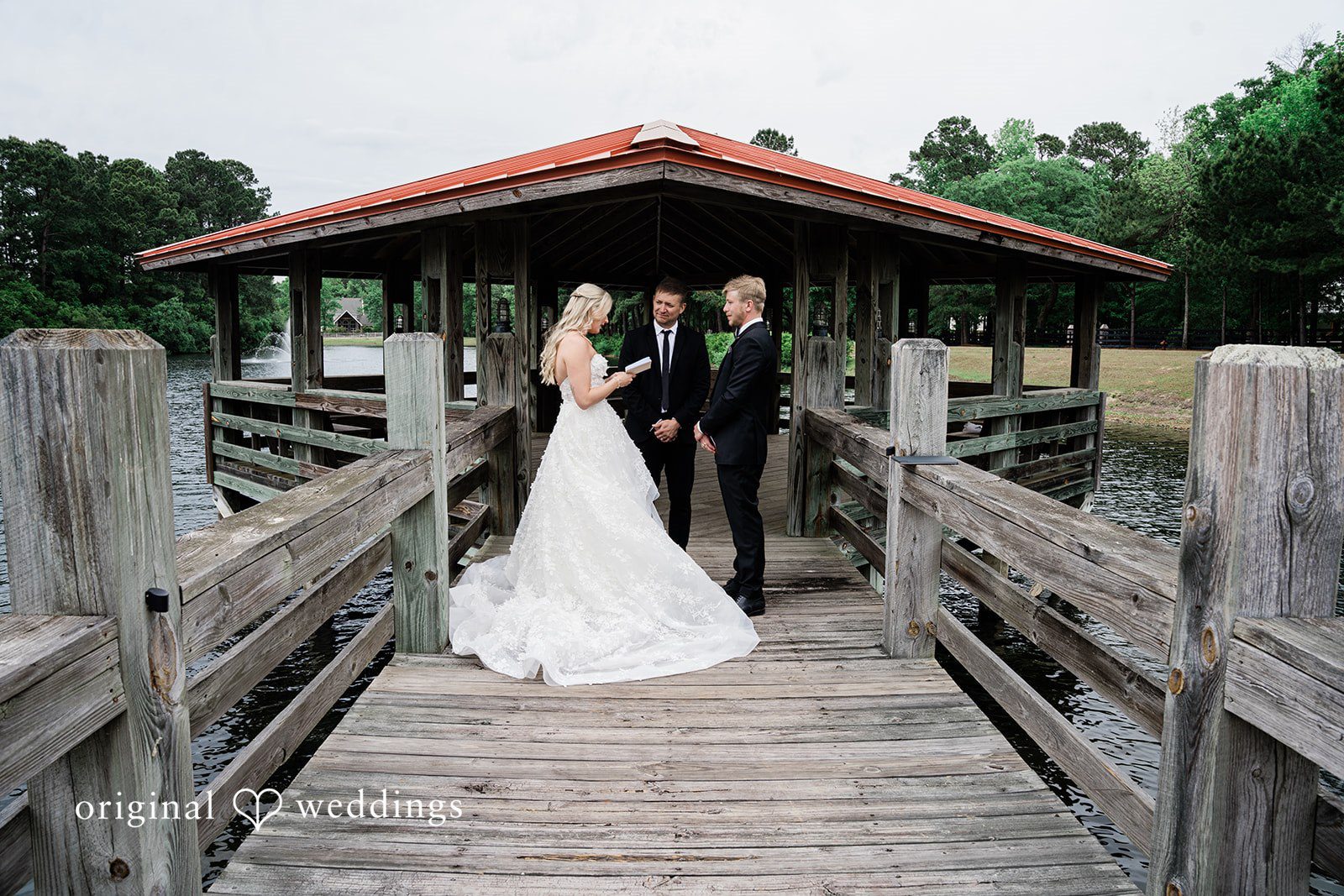 Madeline + John Couple reading vows together on a lakeside dock