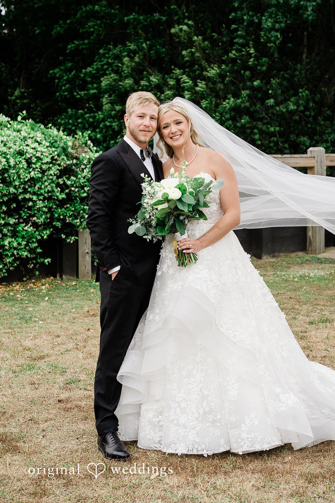 Madeline + John Bride holding her bouquet beside the groom during portraits