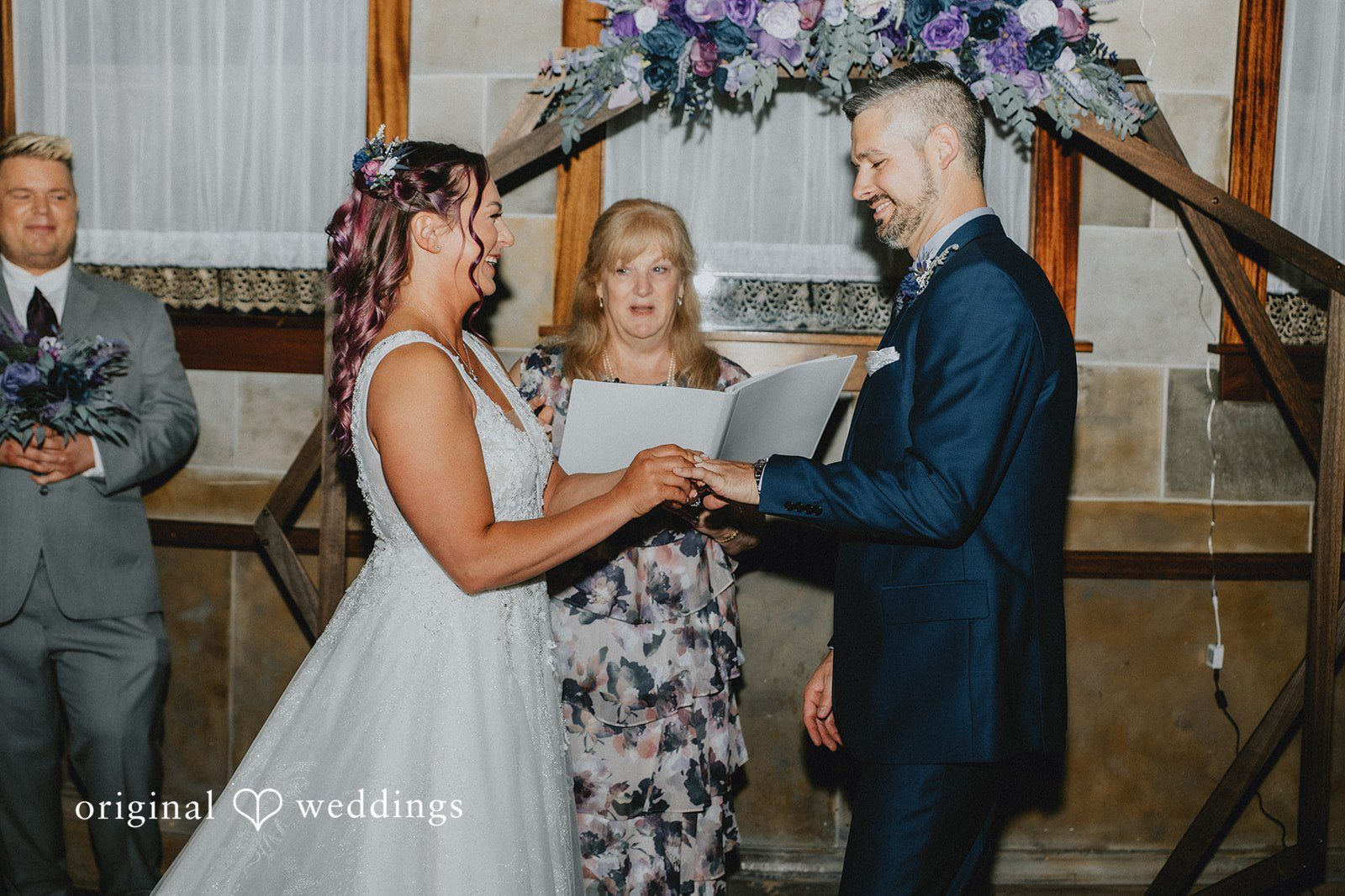 The bride puts a ring on the groom’s finger