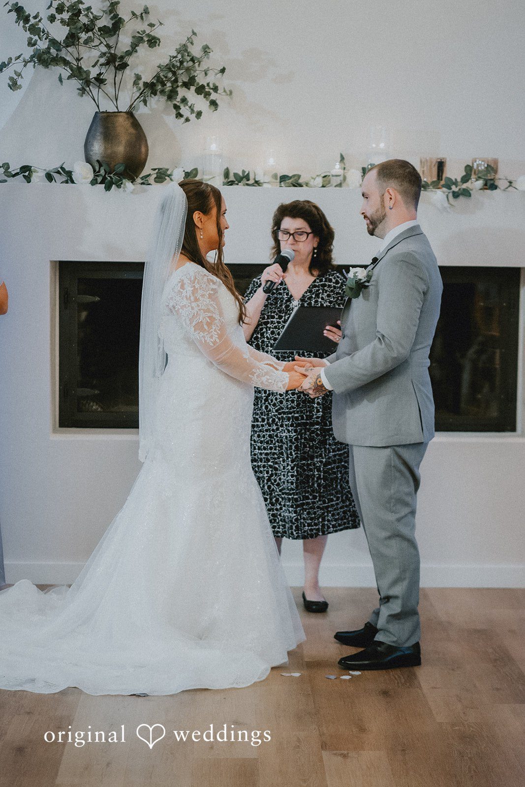 Danielle + Tyler Couple holding hands while sharing their wedding vows