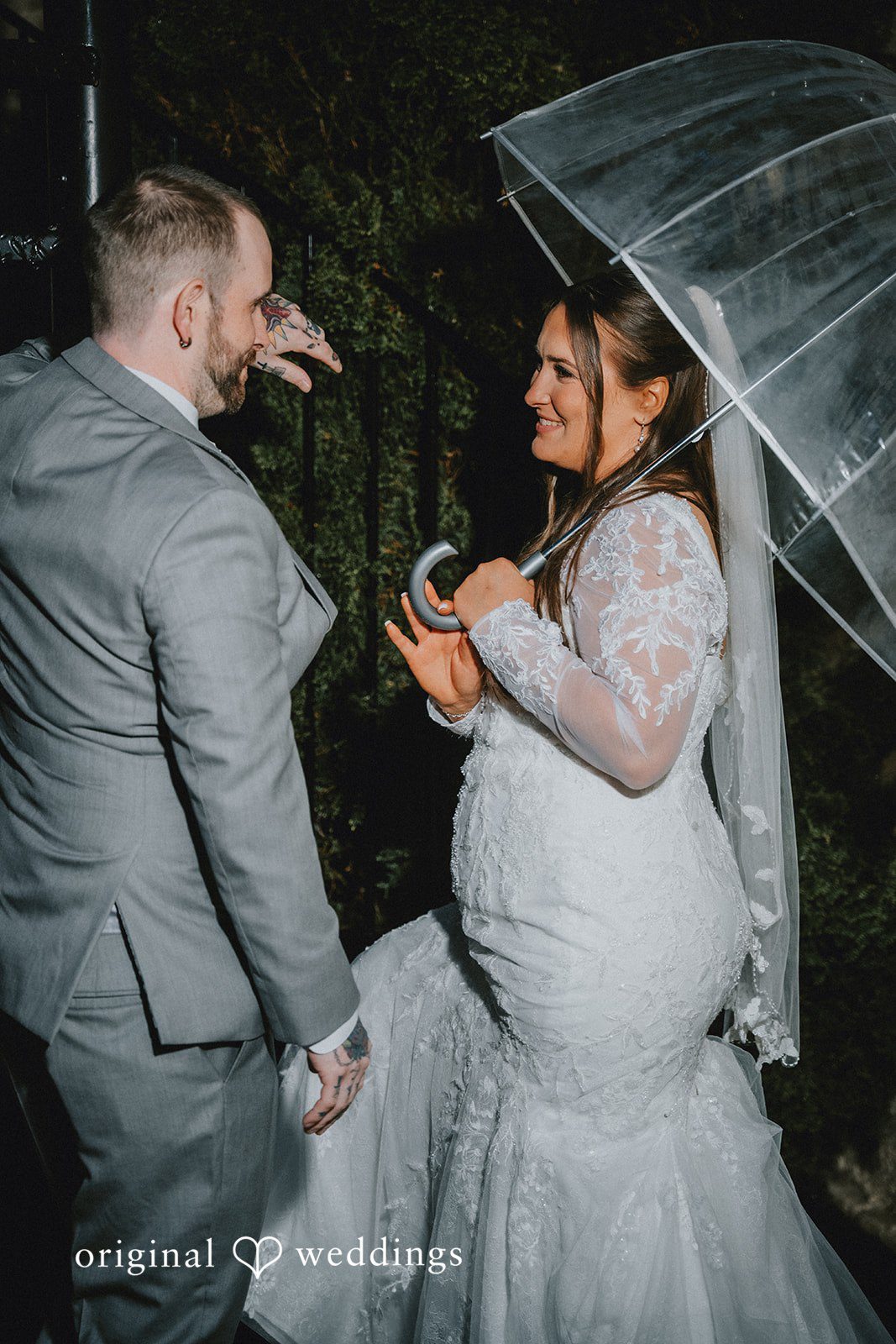 Danielle + Tyler Full-length portrait of the bride and groom standing in the rain outdoors at The Villa at Ridder Country Club wedding
