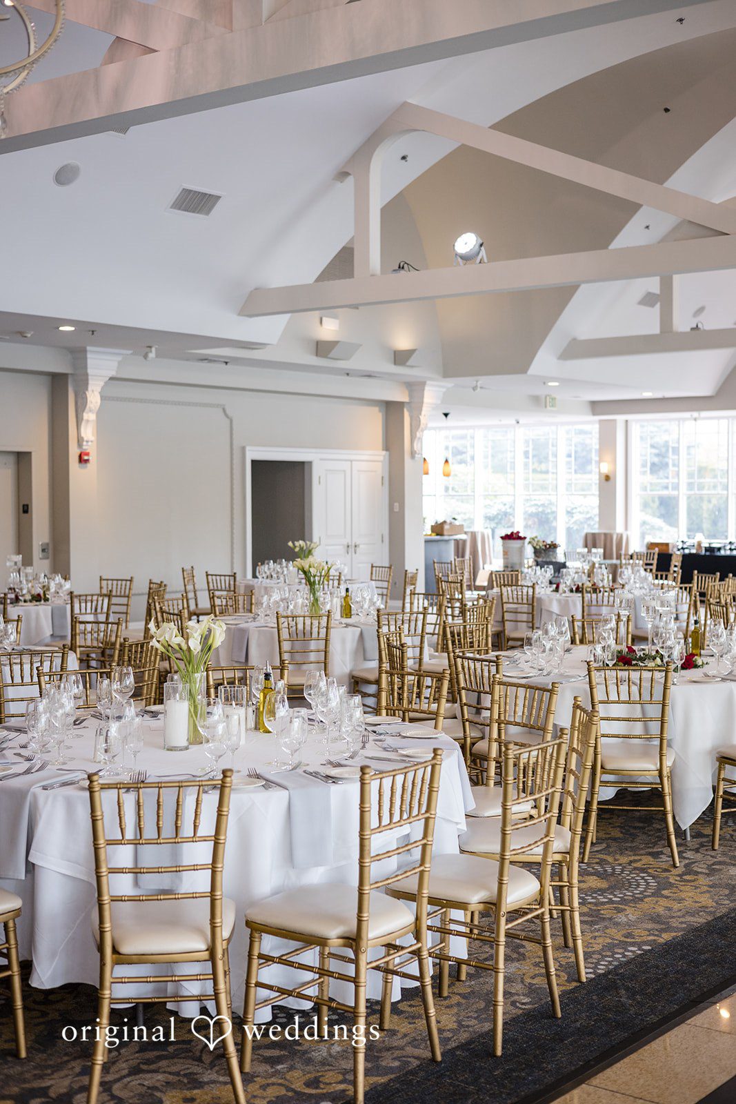 Elegant reception hall with round tables and gold chiavari chairs at The Waterview