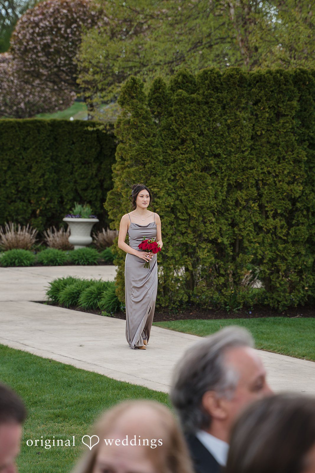 Bridesmaid walking toward ceremony with bouquet