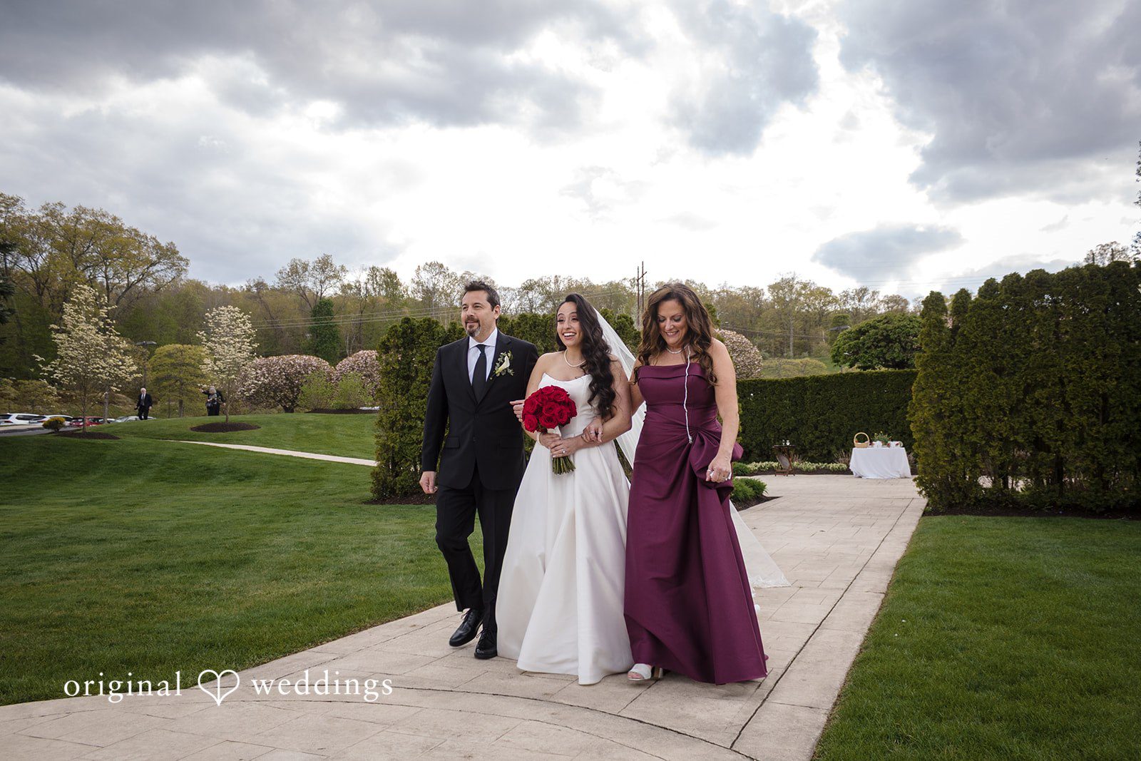 Emotional ceremony entrance as bride smiles while walking toward the altar.