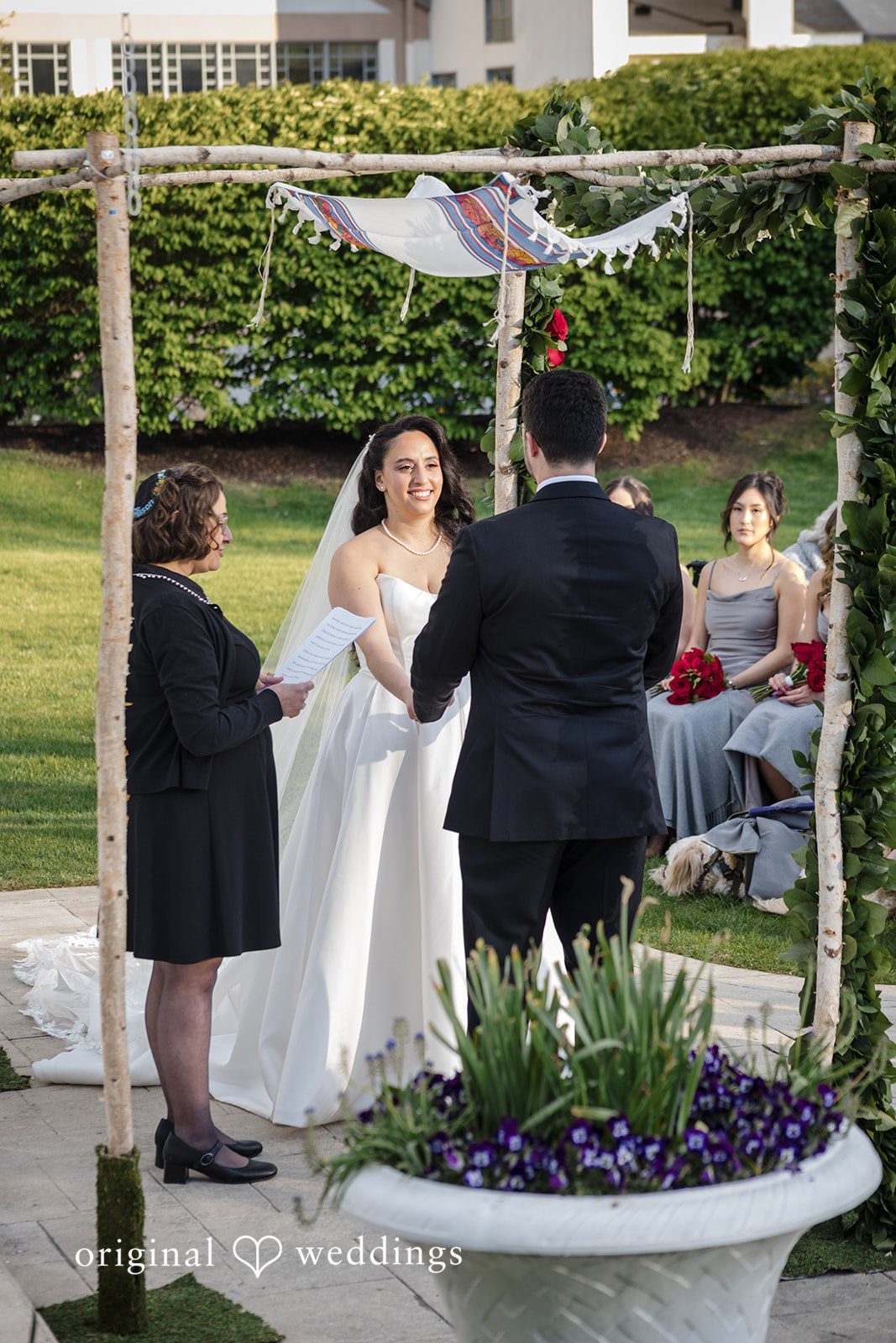 Bride smiles at groom during outdoor wedding ceremony