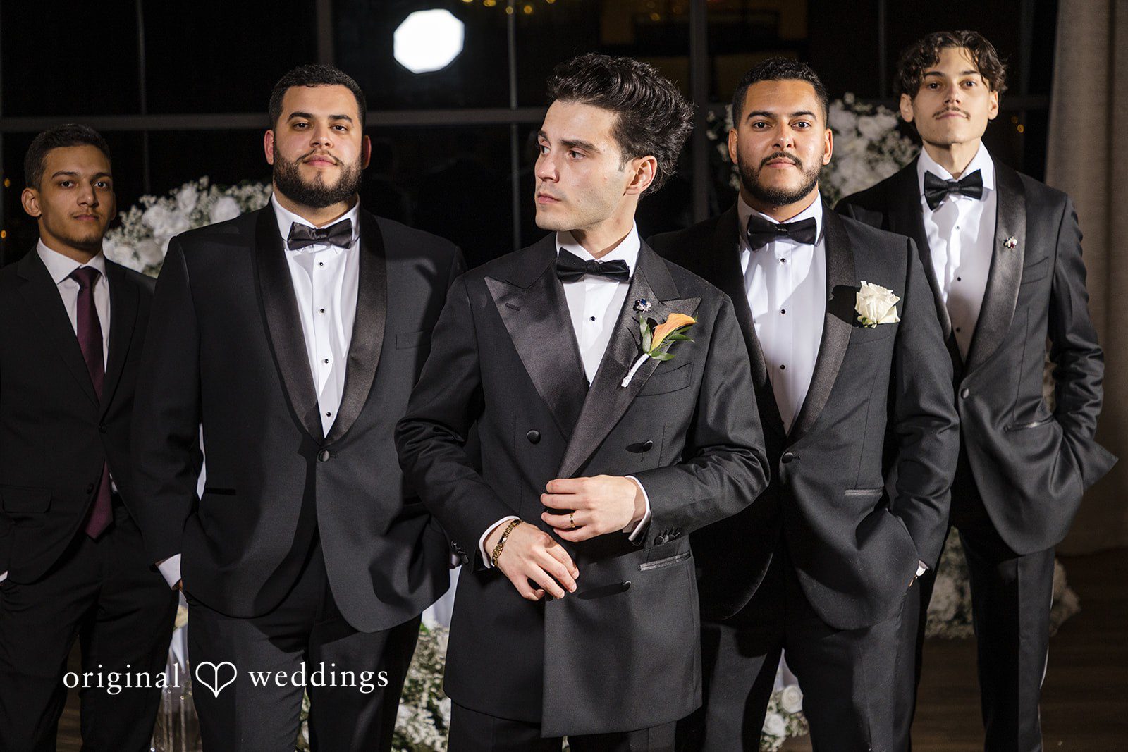 Maria + Eddy Groom and Groomsmen in matching black tuxedos stand together.