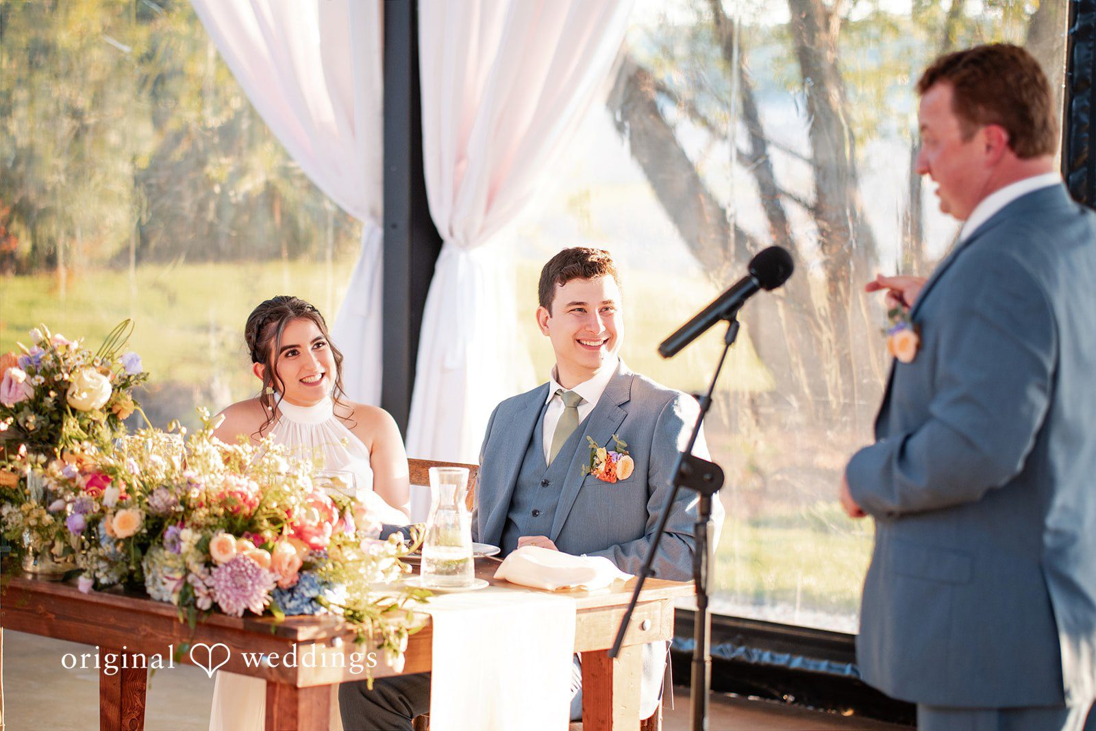 Wedding couple listening to a heartfelt reception speech.