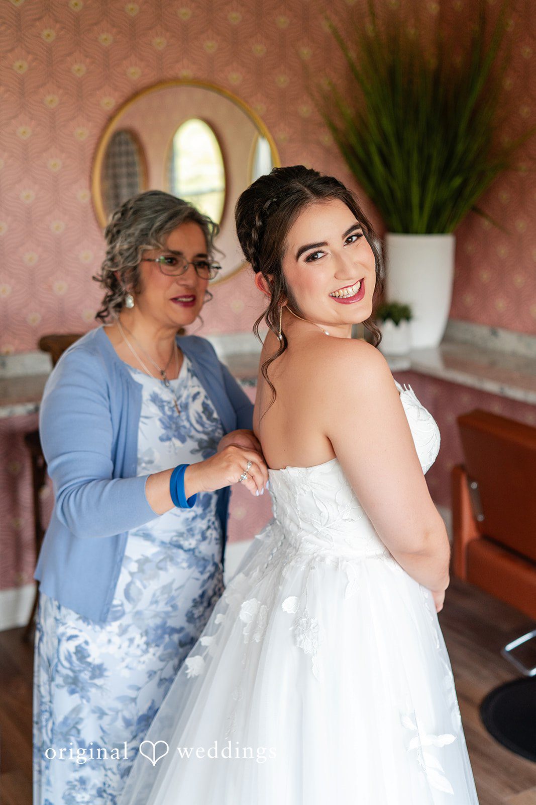 Getting ready picture of bride with someone.