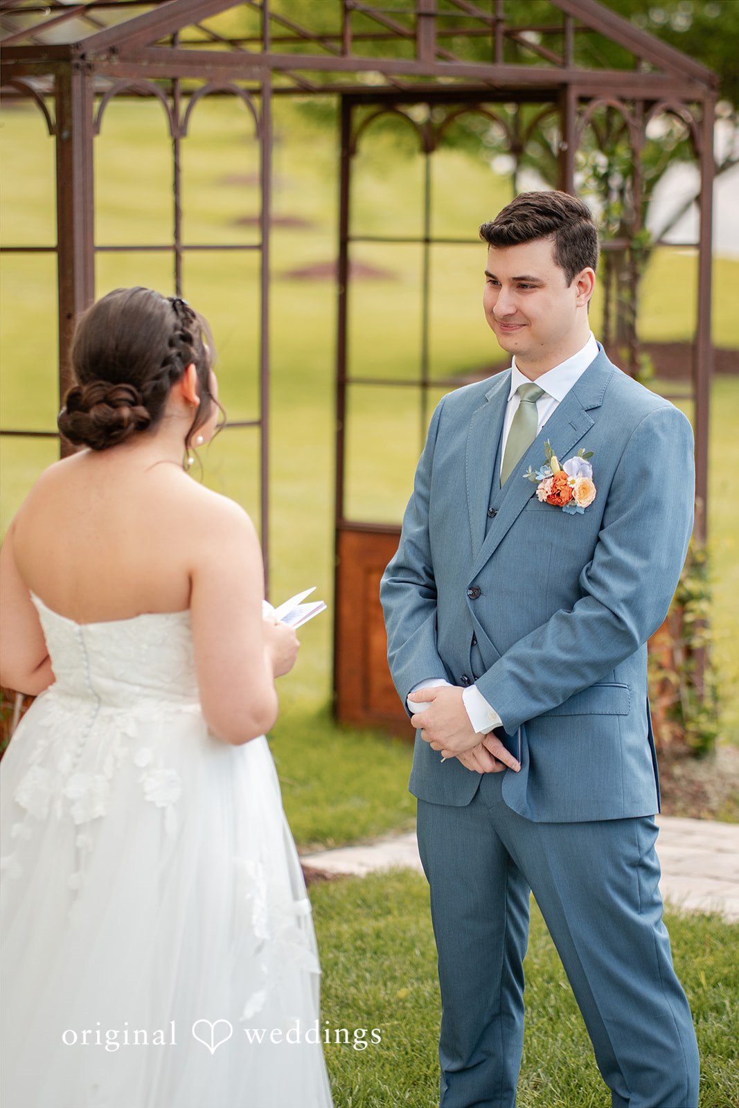 Bride reading her vows to the groom during an outdoor wedding ceremony.